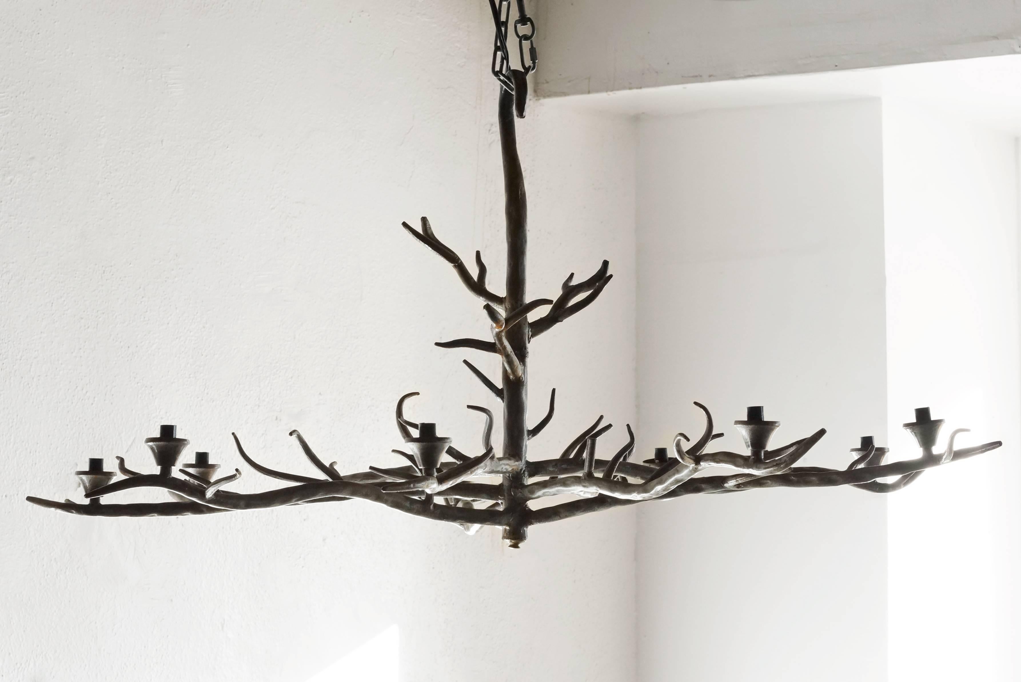 Large tree branch-shaped chandelier of formed steel with patina finish. This artist-made, sculptural piece is wonderfully unique.  C. 1990. Fully-functional.

Dimensions: 46