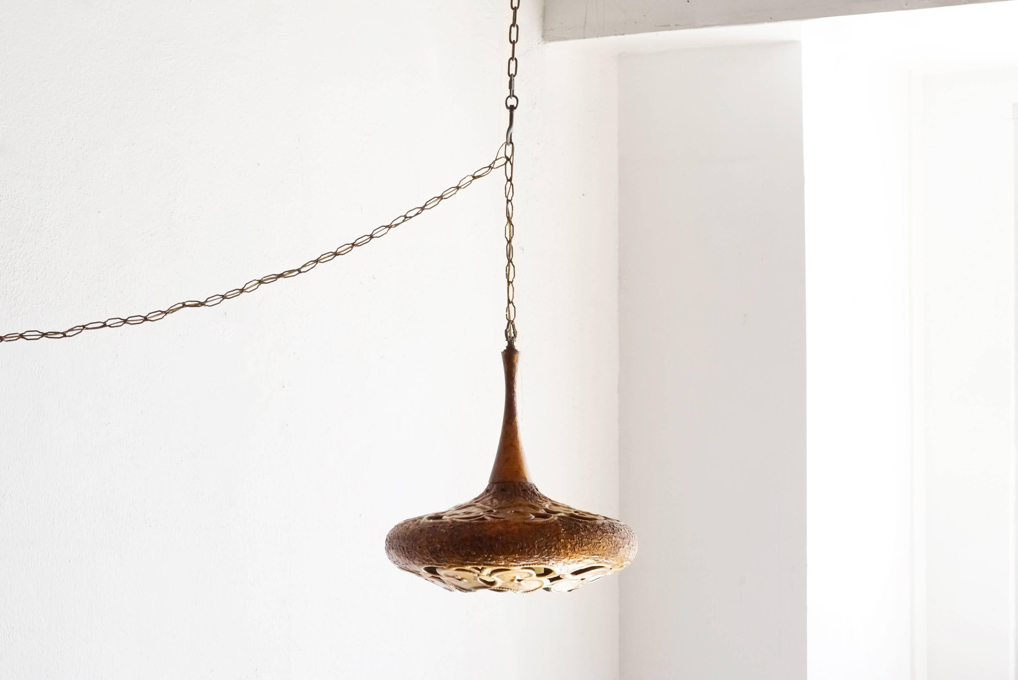 This stunning 1960s sculptural pendant light combines brutalist and Moroccan aesthetics. Its ceramic tear-drop shaped body has a unique metallic glaze giving if the effect of weathered brass; emerald green interior. Fully-functional.

Dimensions: