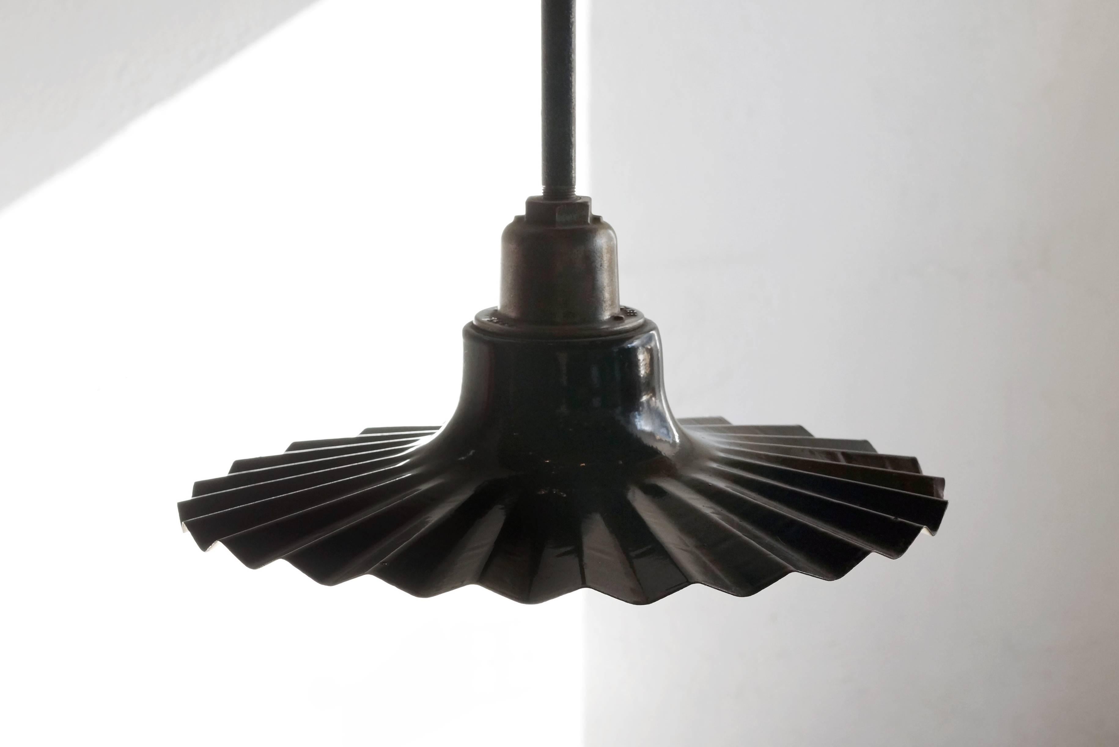 Porcelain hanging street light by Benjamin Electrical Co., Chicago, Ill, c. 1920s. This uncommon version is unique for its flat, radial wave shape. Features original ceiling cap. Fully-functional. Original porcelain finish is in very good condition,