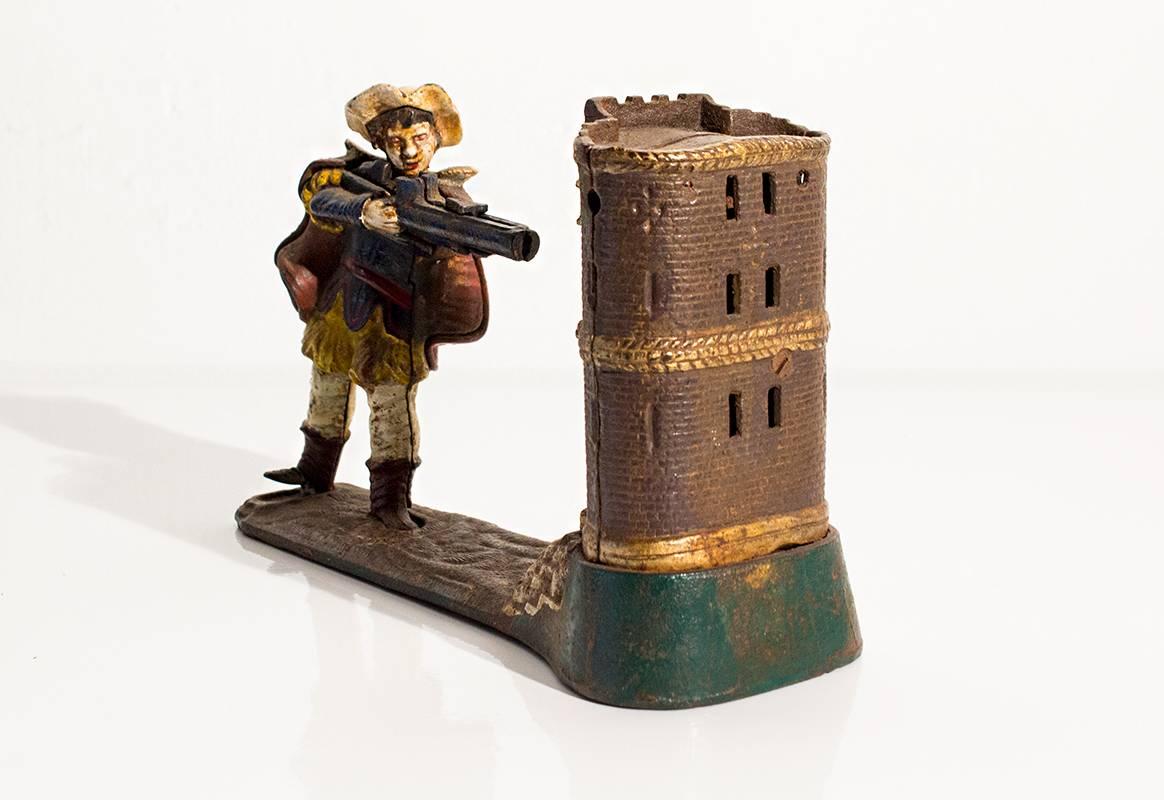 Cast iron William Tell mechanical bank, circa 1896. Coin is shot by pressing the figure's right foot to fire coin into the castle, knocking the apple off the boy's head and raising his arm. Great condition with some paint lose consistent with age.