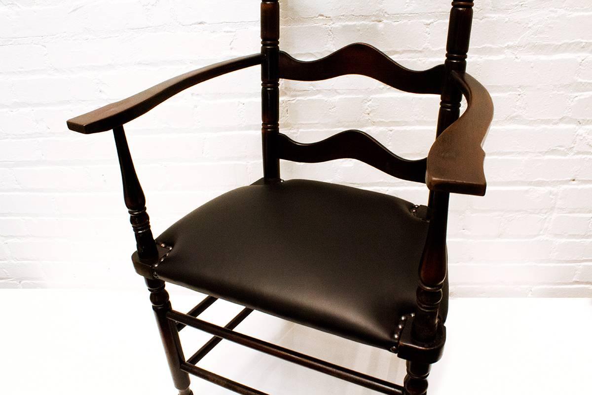 Streamline Victorian era ladder back chair with beautiful brownish black patina.
Clean lines with "wave" rungs on back.

Original rush seating replaced with supple black leather and upholstery tacks. 
A modern twist on a turn of the