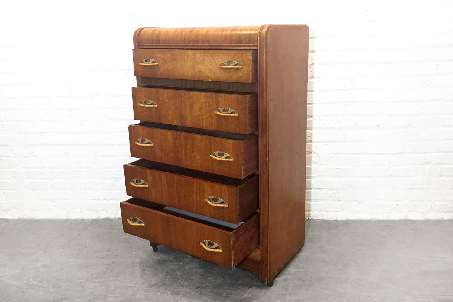 Gorgeous burl wood dresser with rare sculpted brass and bakelite handles. Classic deco shape and details.

Dimensions: 17