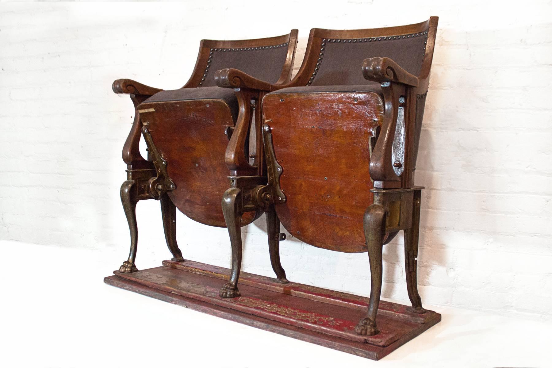 Set of two late 19th century theater seats mounted on wood base. Cast iron legs & hardware with wonderfully refurbished wood. Gray linen upholstery with black upholstery tacks. Very comfortable. Perfect for the home or office.

Dimensions: 29