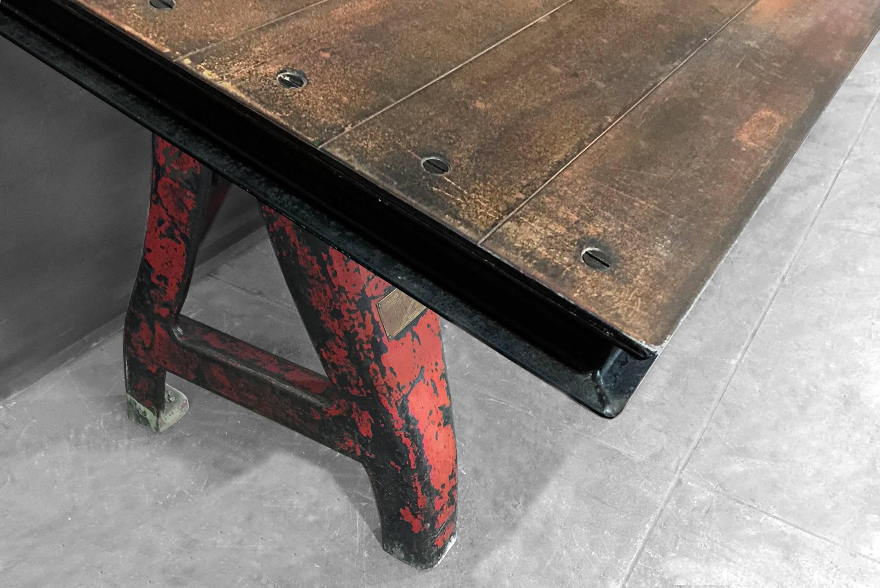 Massive custom-made plate steel top mounted on an antique Industrial machine base. Awesome vintage patina on legs and distressed tabletop. Currently on a tilted riser. Can be mounted flat to serve as a conference or dining table. Dimensions: