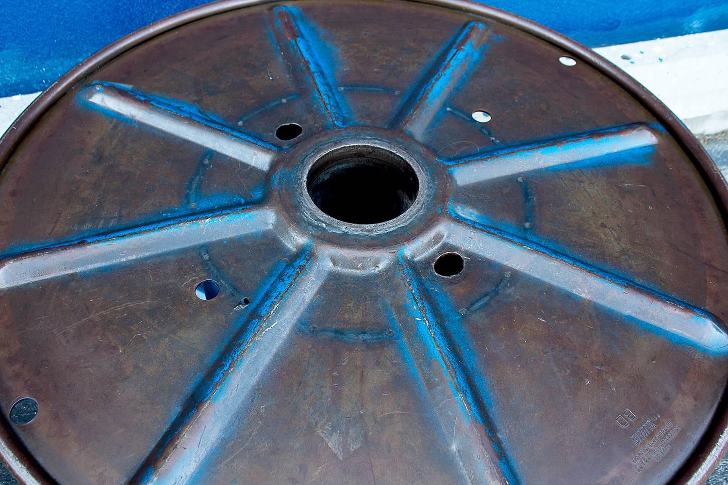 Rare vintage steel cable spool with distressed blue paint finish. Can be made into a great round upholstered bench or glass coffee table. Excellent Industrial centrepiece for the loft dweller. Very heavy.

Dimensions: 36" diameter x 19