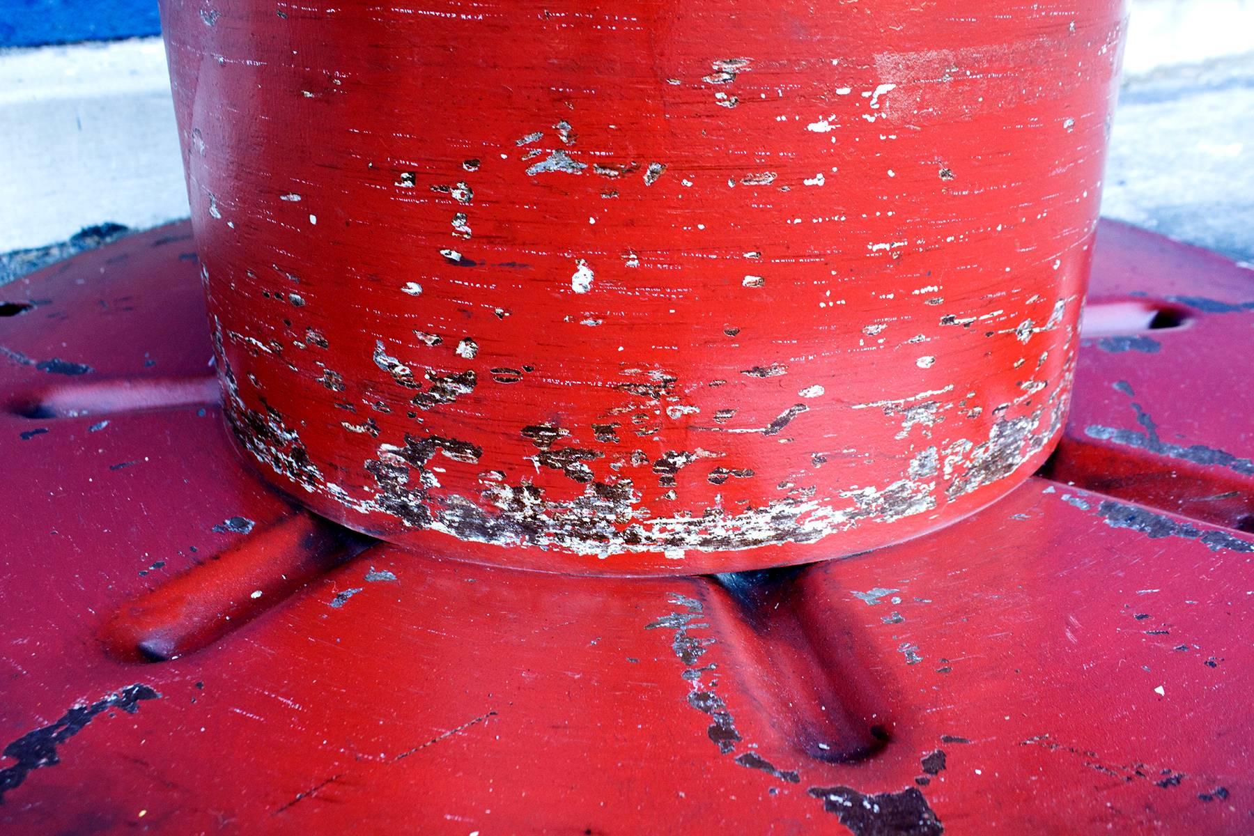 Rare vintage steel cable spool with distressed red paint finish. Can be made into a great round upholstered bench or glass coffee table. Excellent Industrial centerpiece for the loft dweller. Very heavy.

Dimensions: 36" diameter x 19