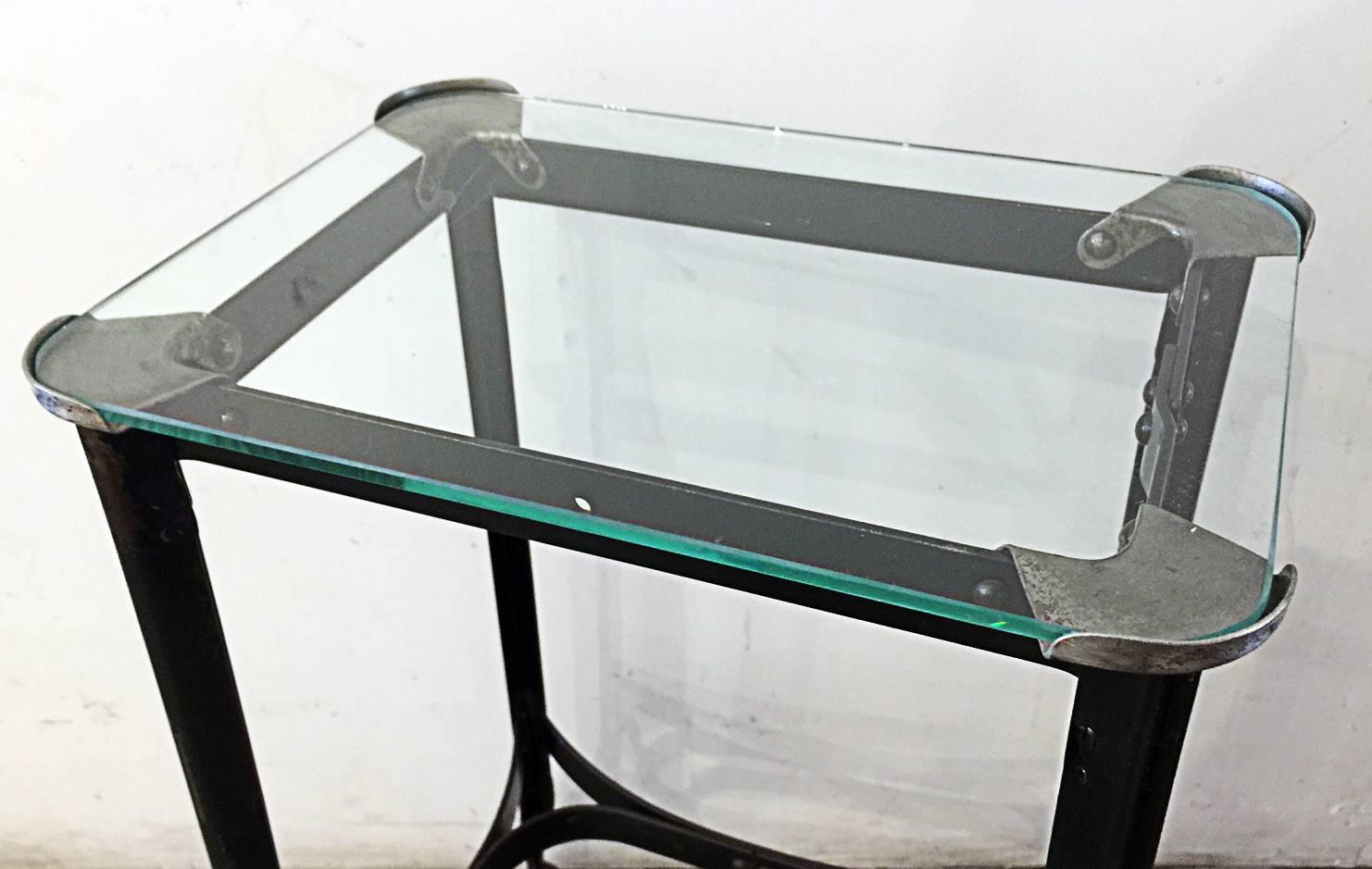 "Petit" rolling side table with glass top secured by Art Deco sculpted corner plates. Very unique style and size.

 Dimensions: 9.25" D x 13" W x 24.5" H.