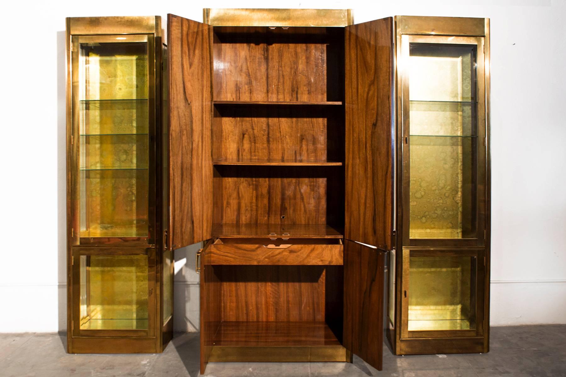 Rare three-piece set of mastercraft ebano wood and antique brass display cabinets from a Brentwood, CA Estate. Custom ordered for a 20th Century Fox Executive in 1983. Set consists of:
Large storage cabinet “model # 1850” ebano wood, antique brass