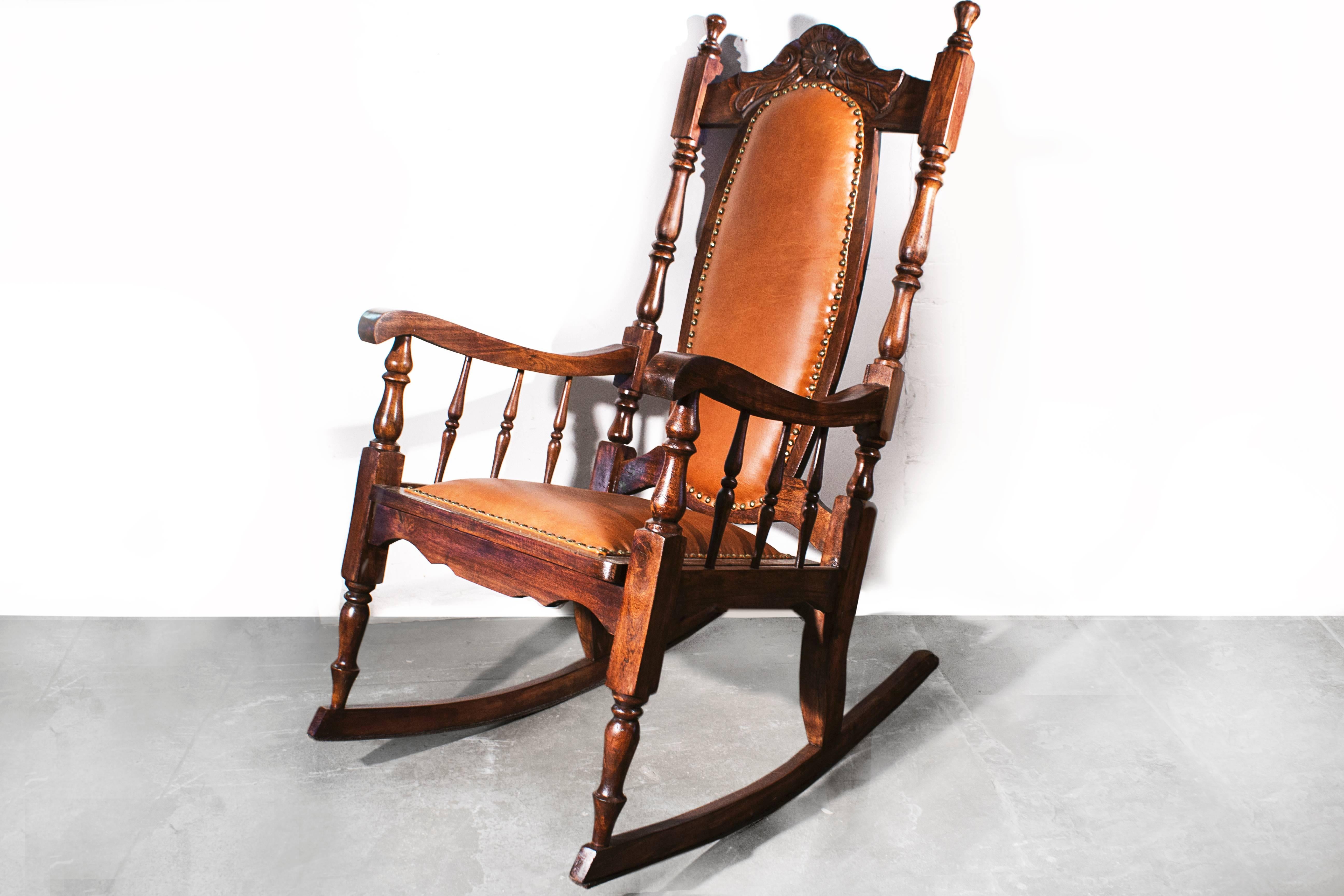 Antique oak rocking chair with hand-carved frame and spindle arms. Original caning has been replaced with new high quality leather and upholstery tacks. Rockin' in comfort. 

26