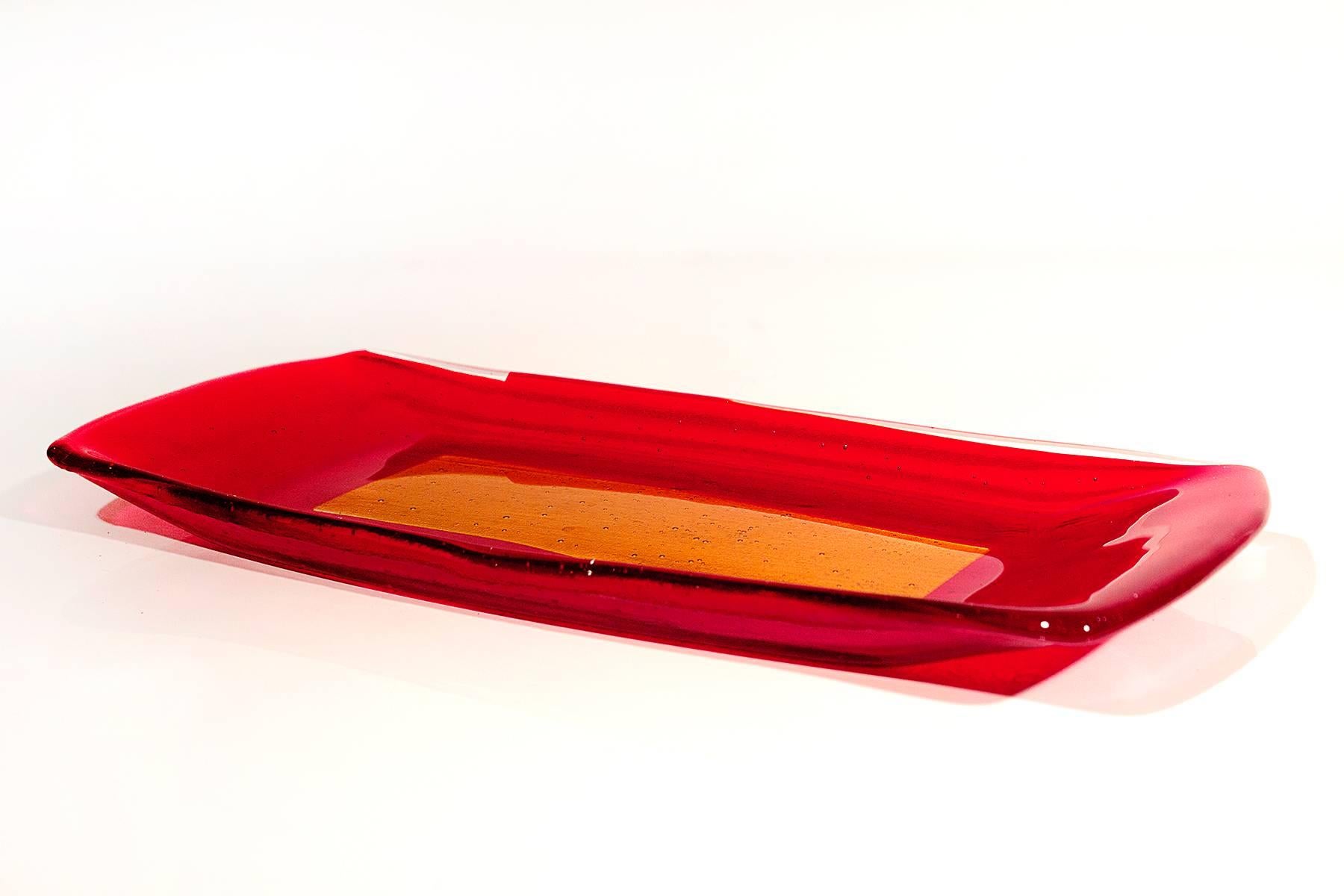 Well crafted red and yellow art glass tray with curved sides. Smooth surface with textured underside. Signed B.

Measures: 10.75" W x 5" D x 0.75" H.