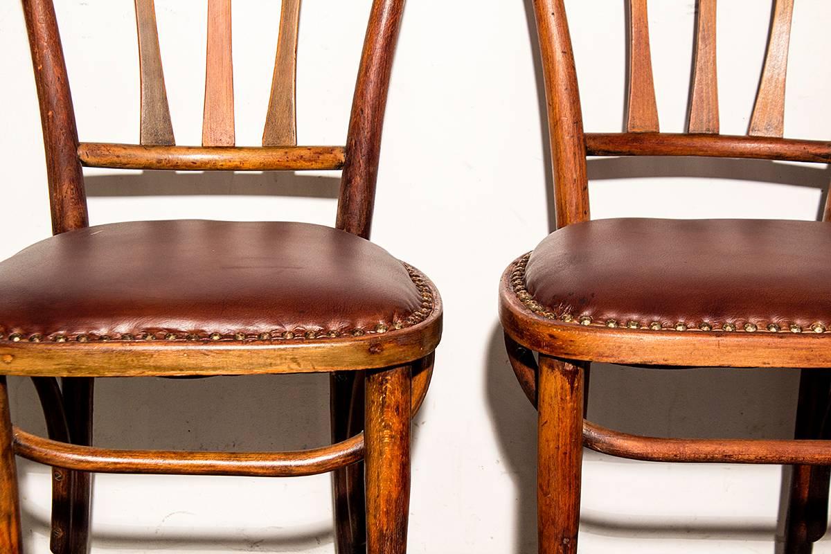 Unique pair of Thonet slat back bistro chairs. These bentwood chairs feature tapered slats and leather seats. Original wood patina has been lightly cleaned and lacquered. 

Dimensions: 15.5" D x 16.5" W x 34" H.
Seat height: