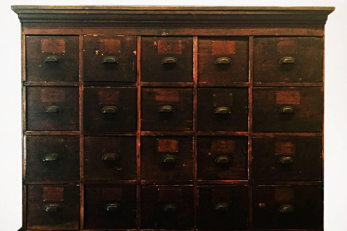 Fabulous antique wood storage cabinet originally from a knitting mill in New York. 
This 30-drawer unit appears to have been constructed from two or three smaller cabinets that have been combined over the years. We have added casters to this beast