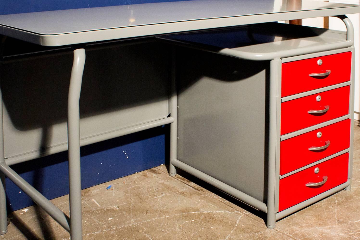 Stellar 1950s Industrial-era school desk by American Seating. The single pedestal base features 4 locking drawers and an open storage cubby. Freshly powder-coated in grey and red with original brushed aluminum hardware. An equally perfect retail