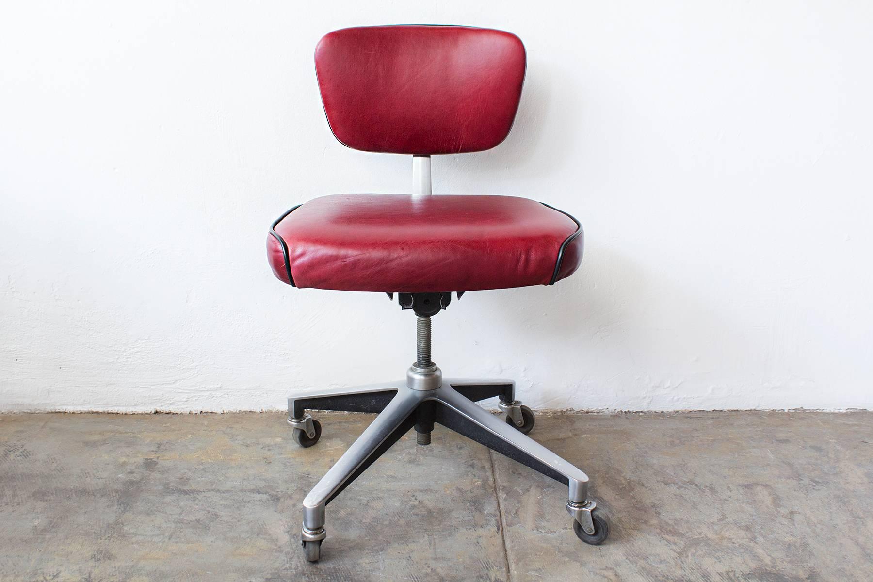 We refinished our retro Industrial steno chair in cherry red leather with black vinyl piping. This Classic 1960s piece is especially unique for its cast aluminium base. Swivels, rolls and adjusts.
