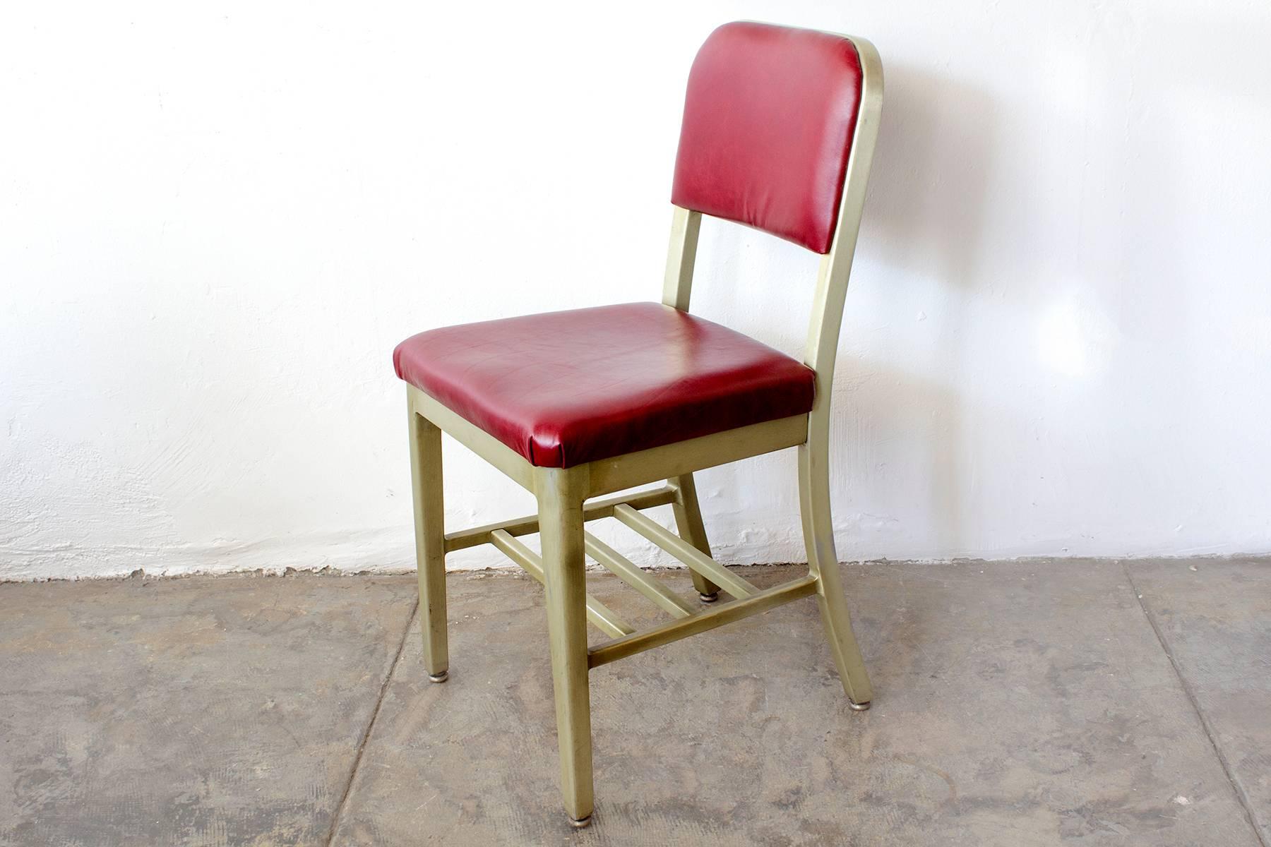 Fantastic set of GoodForm side chairs, circa 1950s. The aluminium frames on these chairs feature an uncommon anodized gold finish that we've polished and restored. Seats are newly reupholstered in a rich cherry red leather. This Classic,