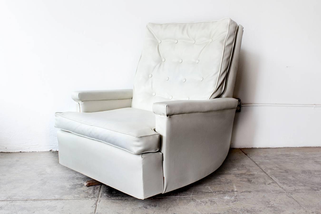 Fantastic 1970s tufted recliner with original white vinyl. Sits on a rocking base. Super comfortable Please inquire about custom reupholstery options at additional cost. 

Dimensions: 34