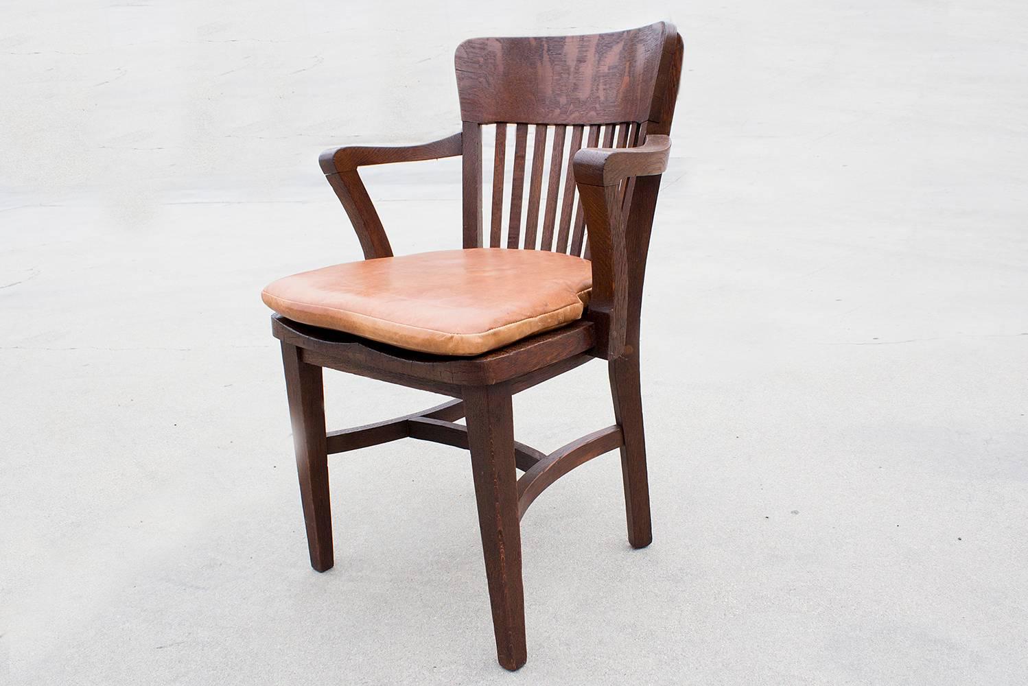 Beautifully articulated oak lawyer chair, circa 1940s. Features newly reupholstered leather seat, slat back and reconditioned wood frame. Excellent refinished condition.

Dimensions: 22.5