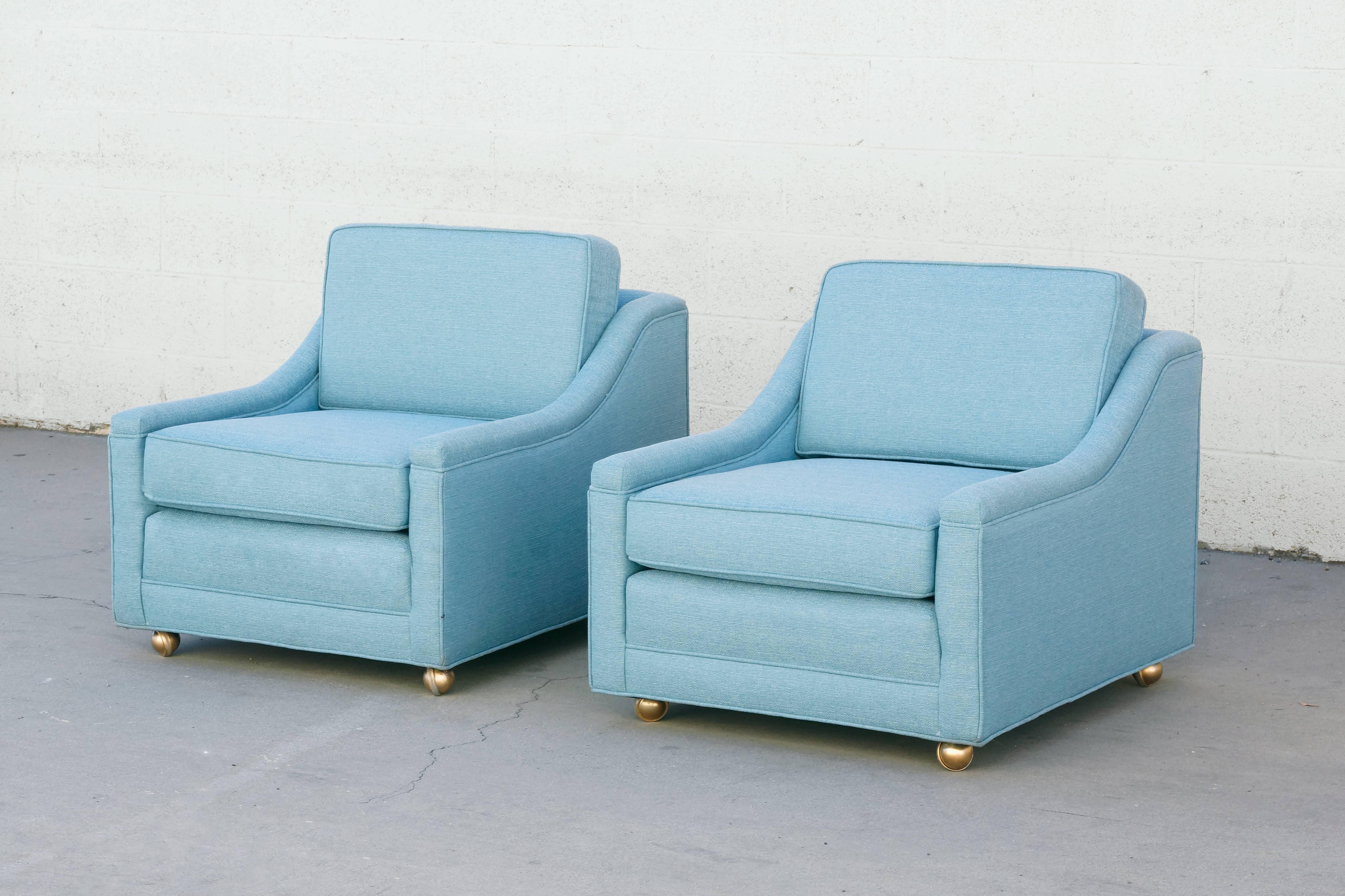 This timeless pair of 1950s loungers are as comfortable as they are easy on the eyes. We've reupholstered them in a sky blue high quality woven fabric. Original hooded brass casters, newly refinished. Oh so lovely Classic American styling.