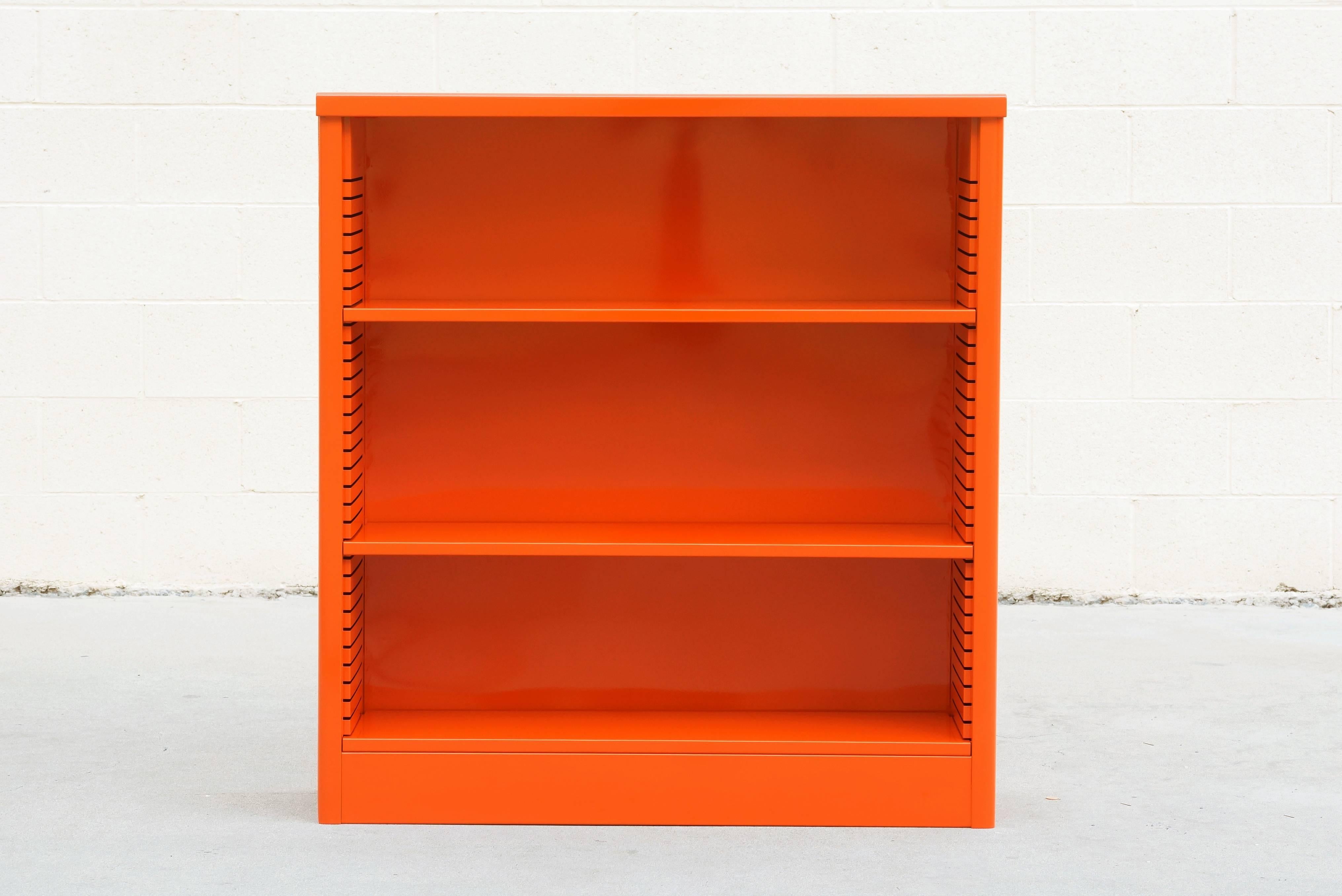 Neat 1960s tanker style steel bookcase freshly powder coated in high gloss orange. Originally used in the UCLA math department, this adjustable three-shelf unit is an excellent storage option– its sleek and compact, yet holds many books. It's
