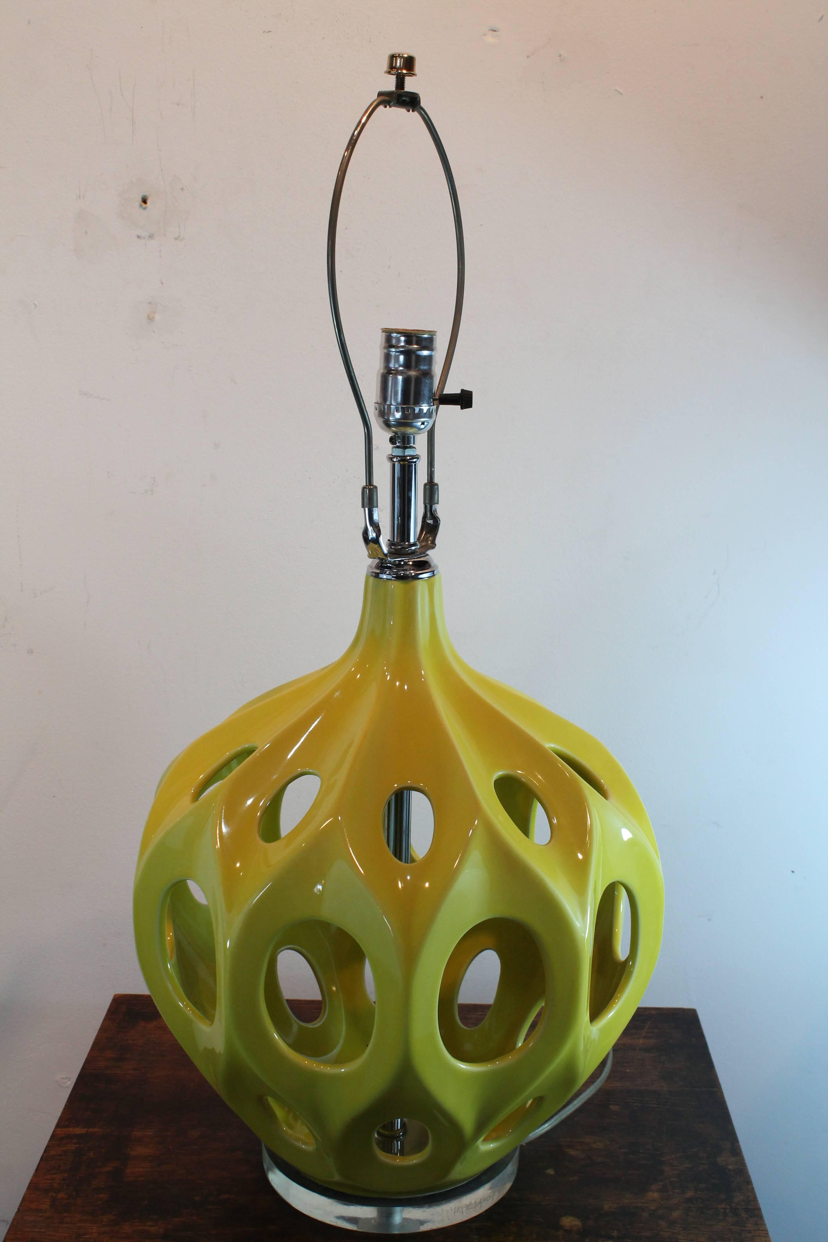 A pop of brilliant yellow on this glazed and pierced ceramic Modernist sculptural form table lamp. Sets on a Lucite base.
Shade not included.