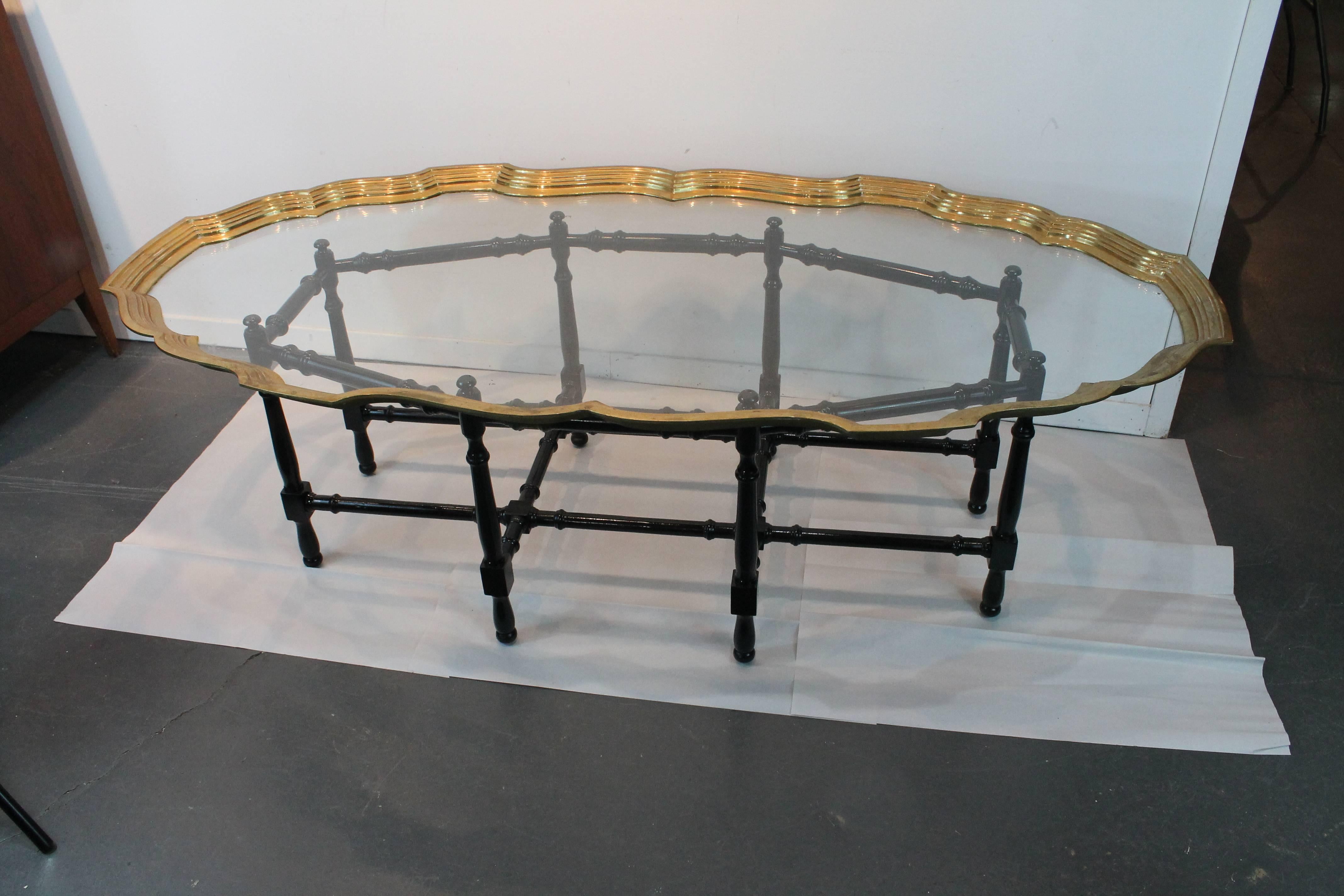 Wonderful Hollywood Regency brass and glass tray topped cocktail table with an ebonized and turned base.
Manufactured by Baker.