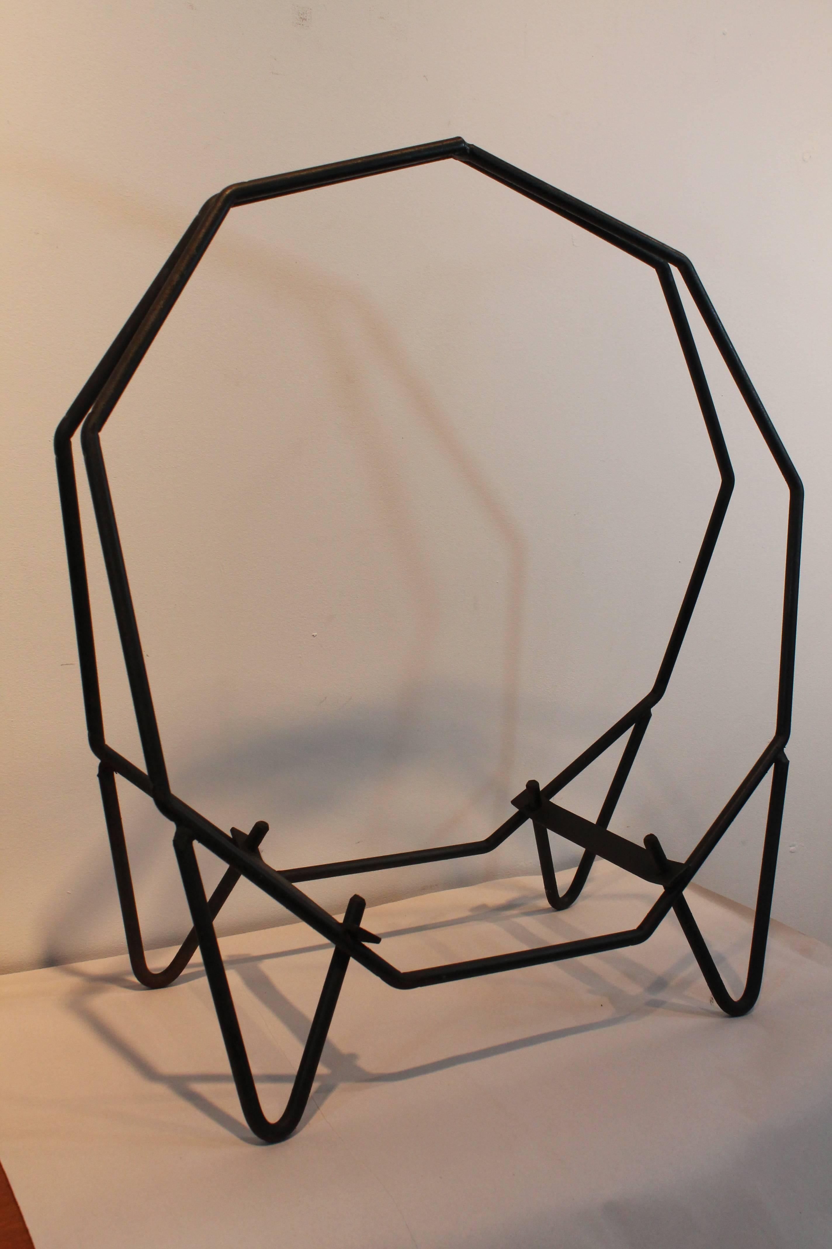 Exceptional modernist form on this wrought iron log rack.
There are two nonogon (nine-sided) geometric shaped forms that are joined at the top and have hairpin legs at the base.
Geometric Minimalist sculptural bliss!