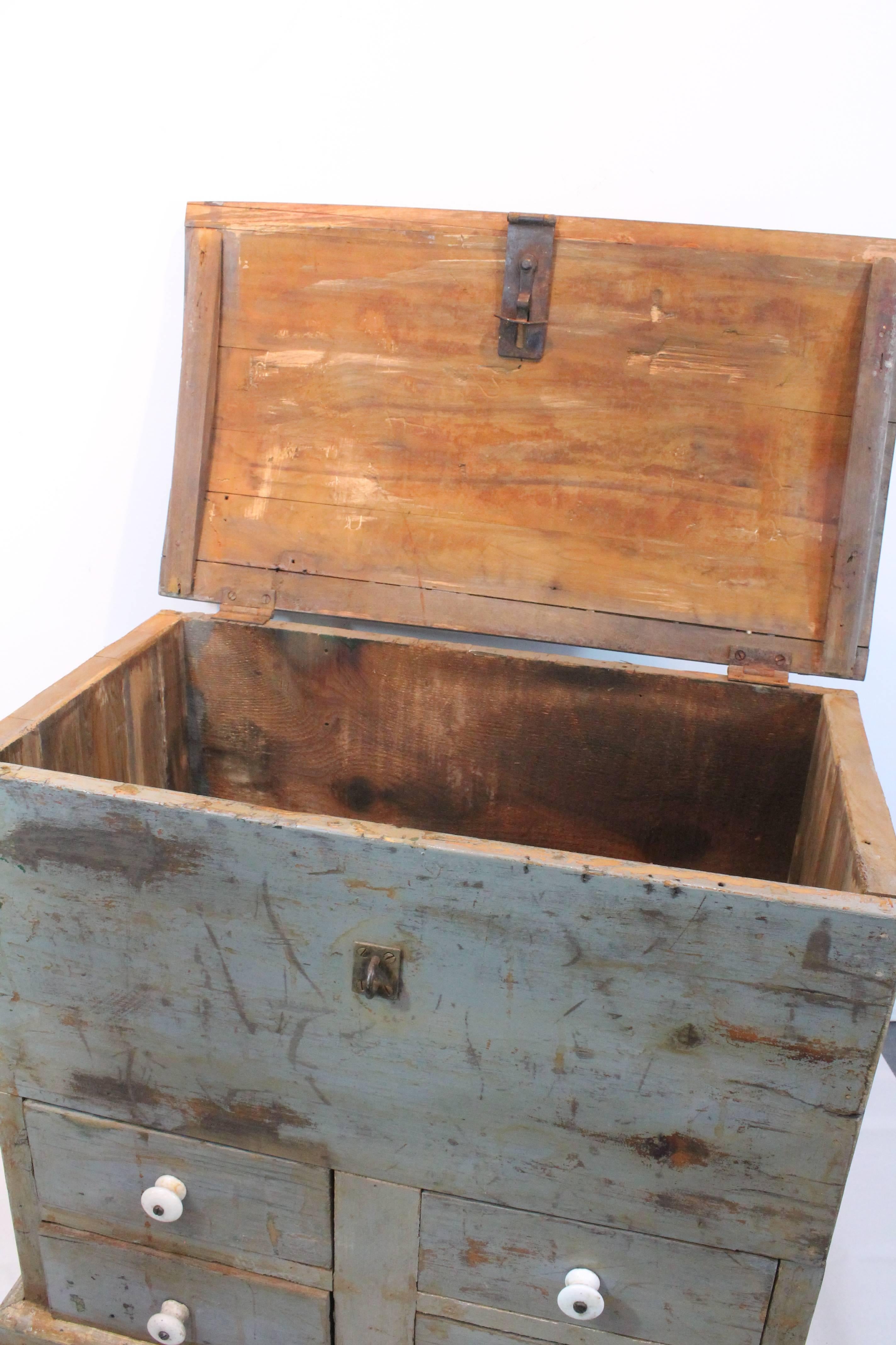 Wonderful distressed painted surface on the large-scale carpenters carrying tool box / trunk with four porcelain pull drawers and a subtle domed top.
Wonderful iron hinged lock opens the top to reveal the inner storage compartment.
 