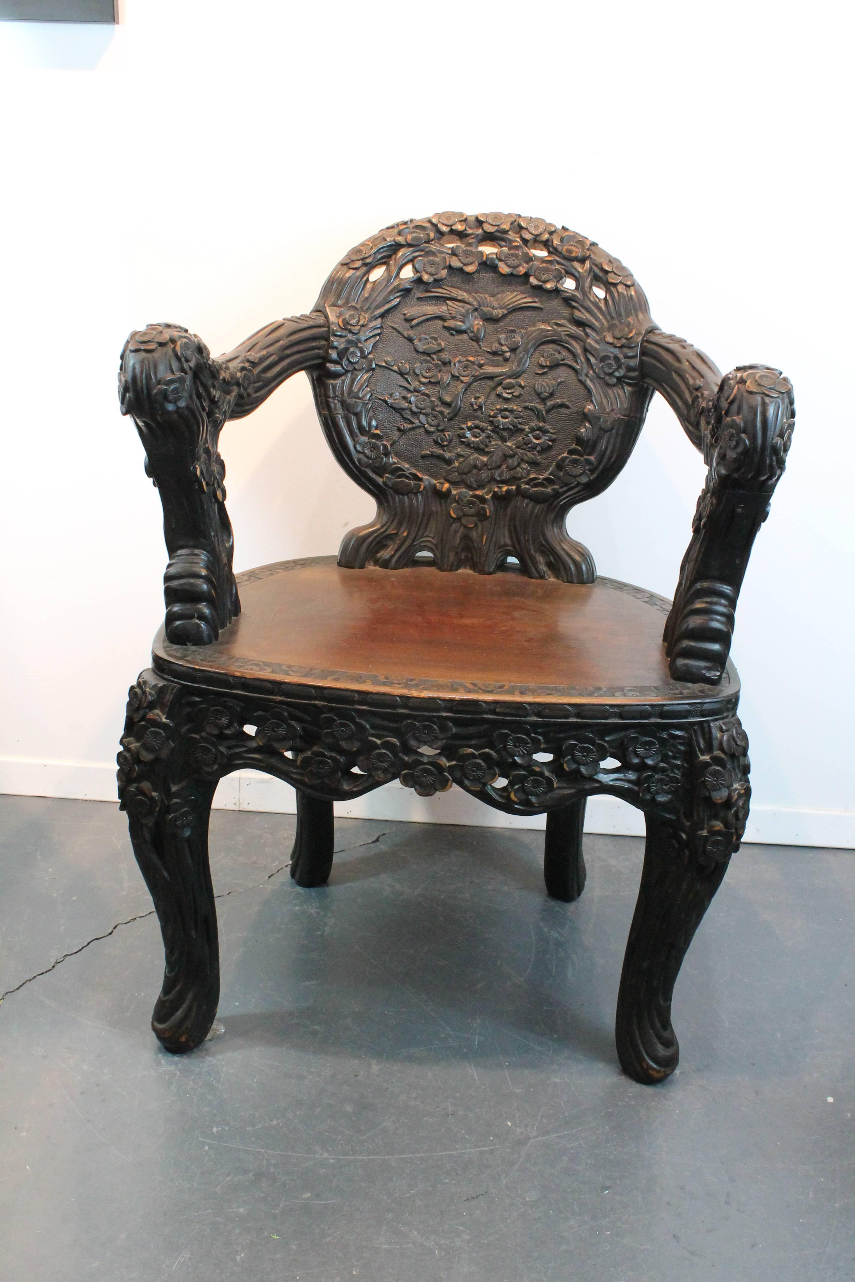 Early 20th Century very heavily carved Chinese arm chair with cherry blossoms throughout the legs , skirt , arms , and seat.
The back is a carved cloud form design and the back rest has a scene with cherry blossom limbs and birds.