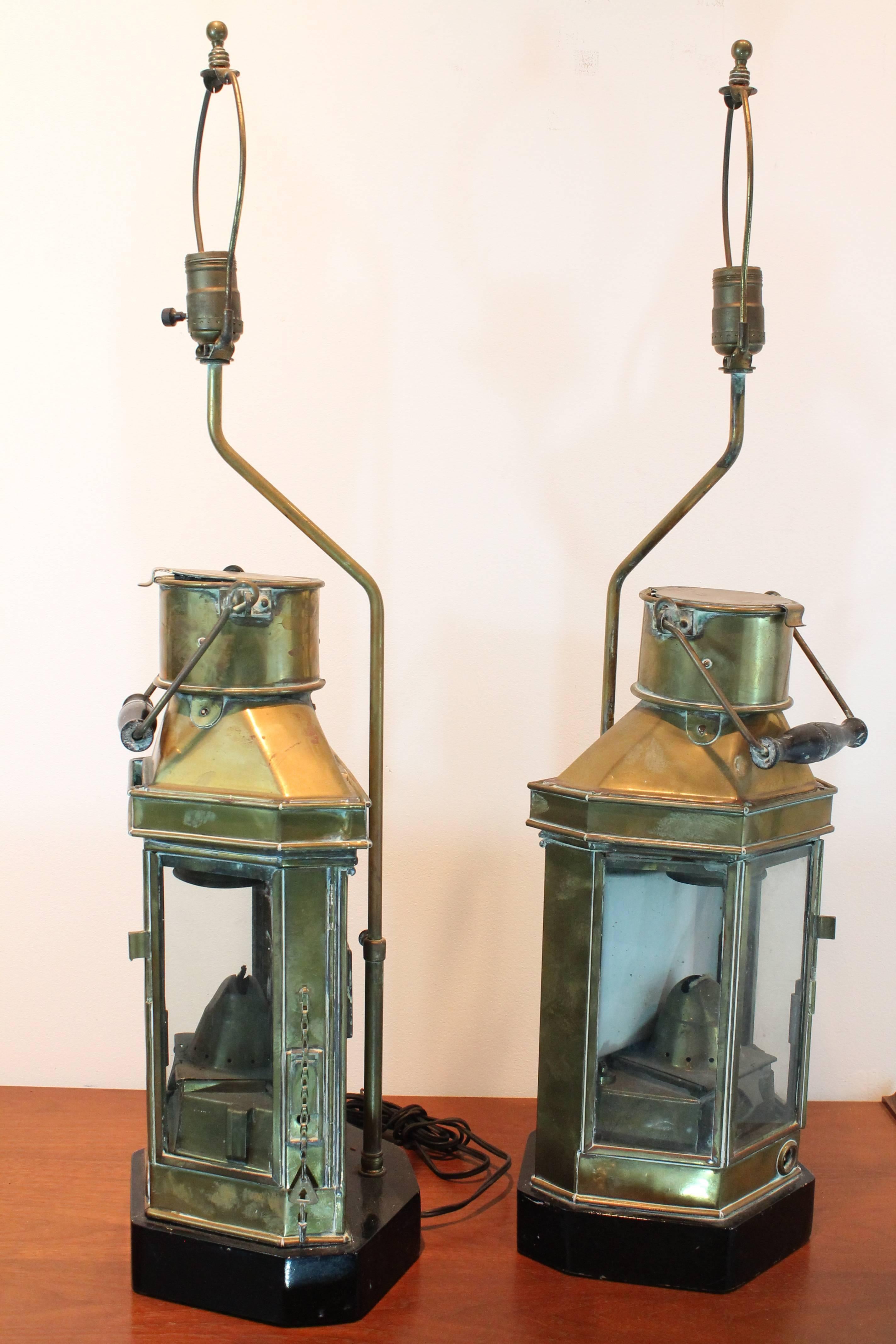 Great pair of brass ship oil lanterns that were turned into lamps and set upon ebonized wood elongated octagonal plinths.
Stamped 