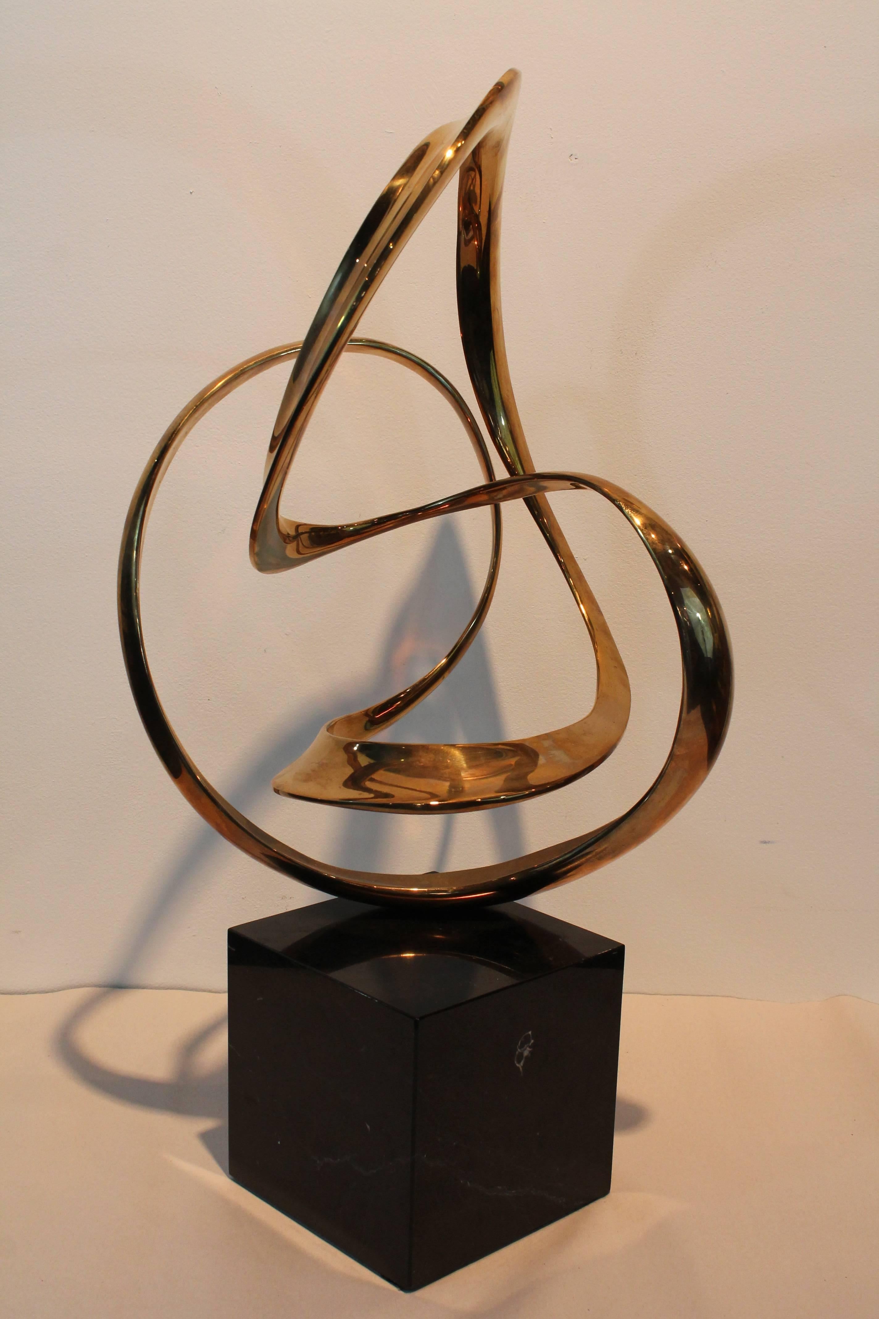Exceptional form from every angle on this Modernist ribbon form brass sculpture on a marble plinth.
Signed Tom Bennett. 21 /100,
1986.

 
