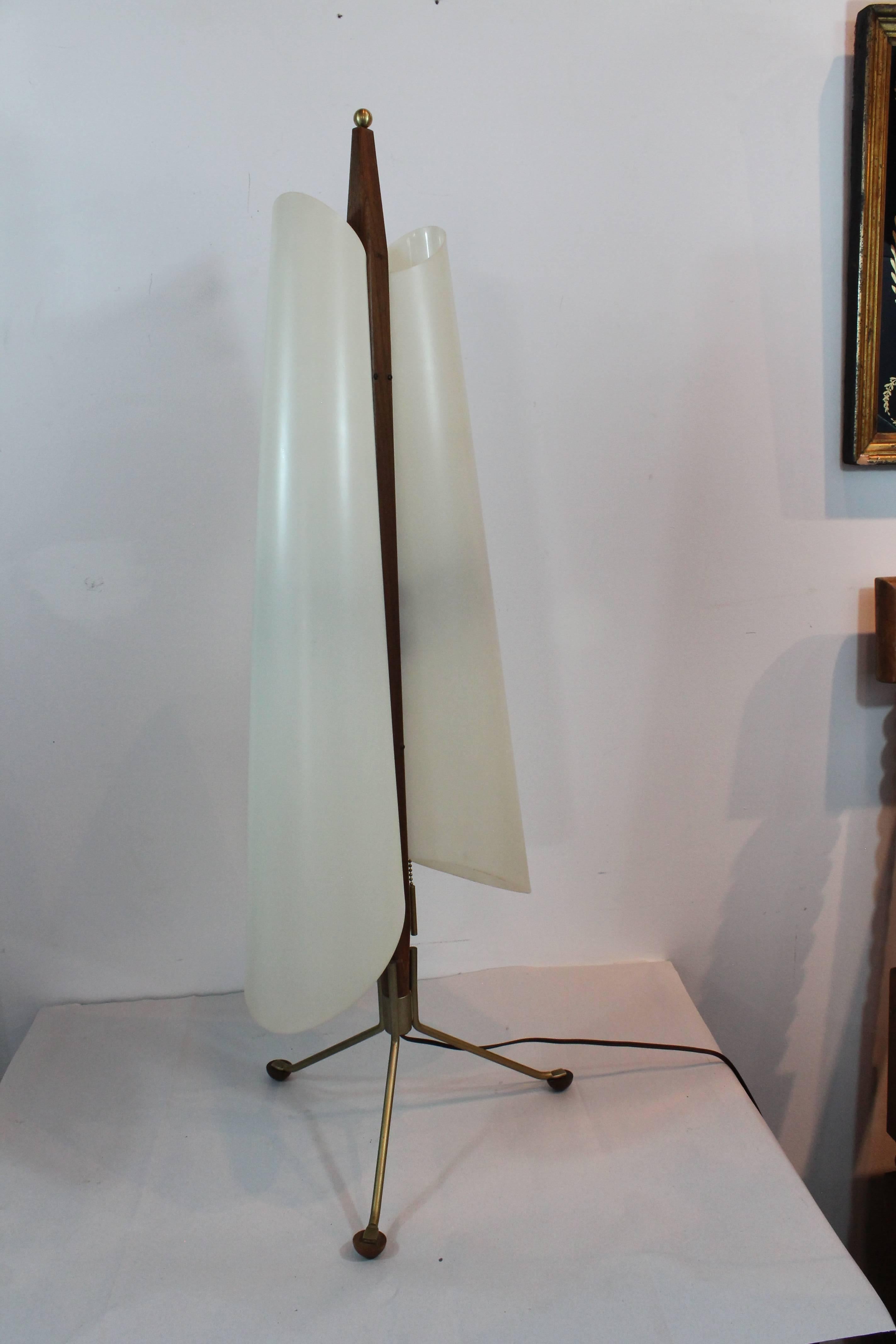 Elegantly proportioned large-scale Mid-Century Modernist tripod based table lamps.
Exceptional sculptural Minimalist form featuring walnut and brass details with a pair of plastic side shade forms concealing an up and a down bulb on each