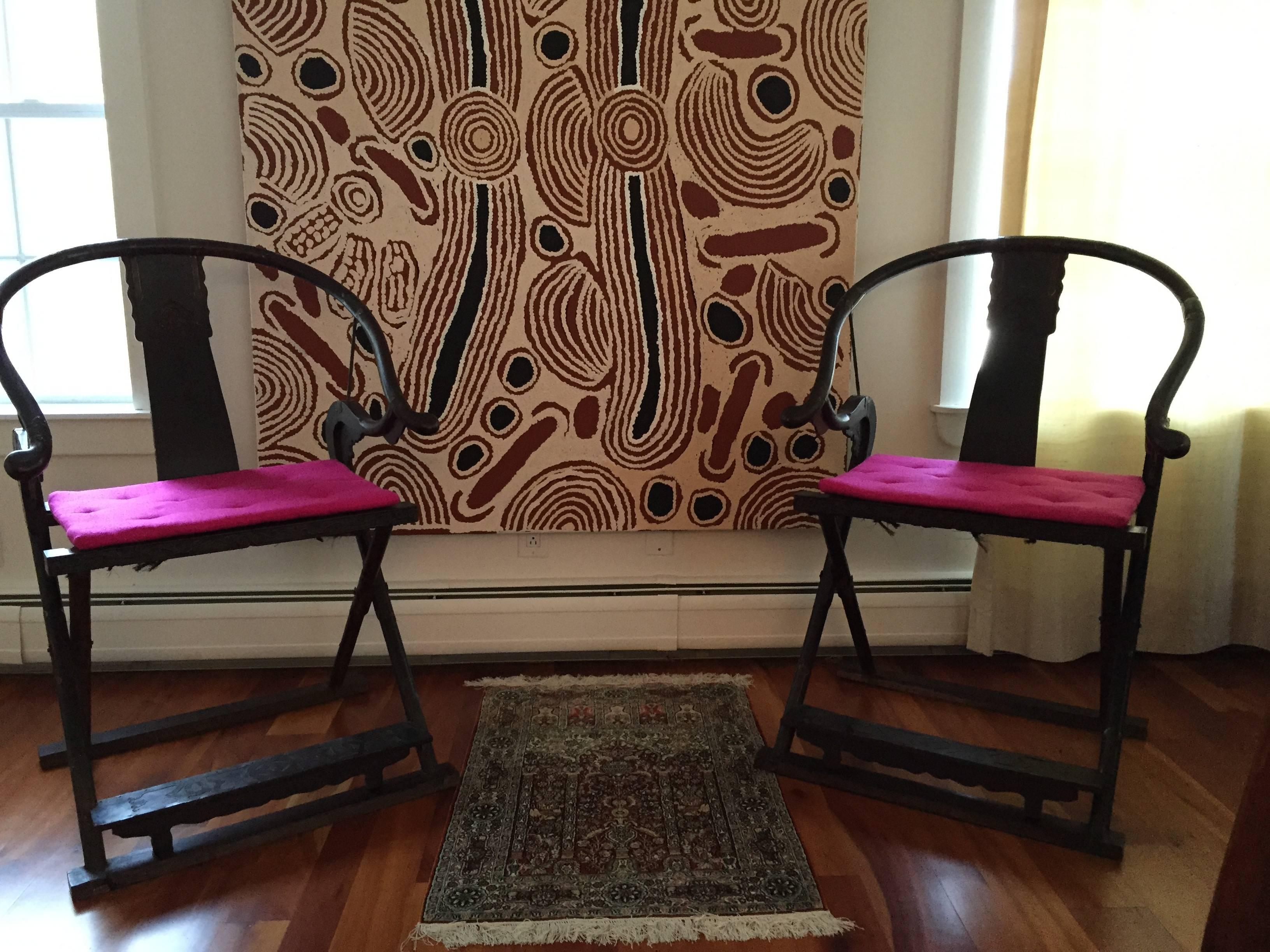 A pair of Chinese folding horseshoe back armchairs, "Jiaoyi," likely dated late Qing dynasty or earlier (1644-1912). They were constructed from a dark wood maybe Zitan, a member of Asian Rosewood that is highly priced for its dense grains