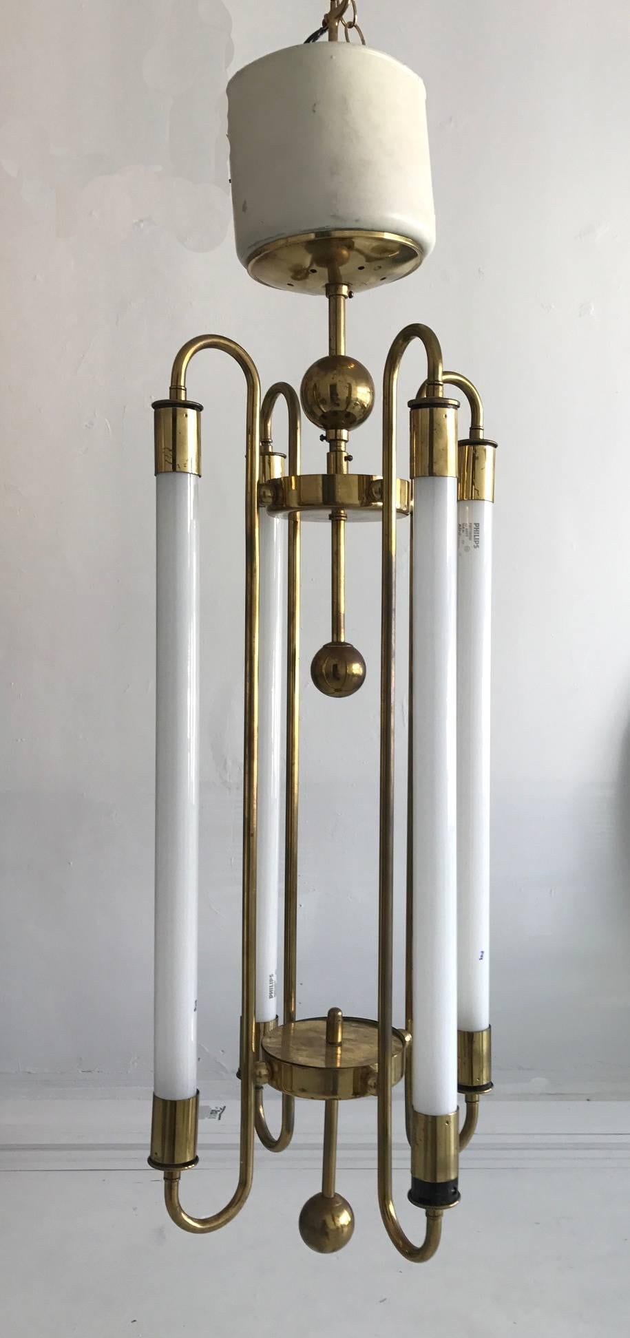 A brass and enameled chandelier by Kaiser & Co, made in Germany, circa 1940s. In the fashion of Art Deco transitioning into Modern and Bauhaus. Polished brass frame with large balls supports four fluorescent tubes. It makes a beautiful ceiling
