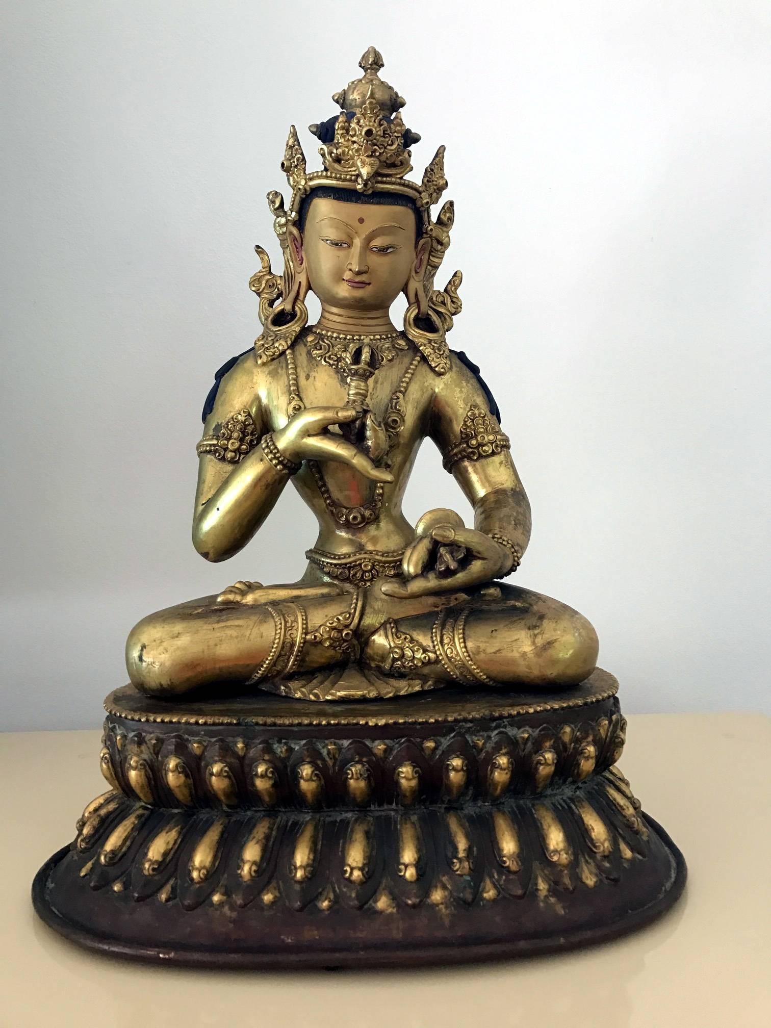 Angeboten wird eine beeindruckend große und fein gegossene sino-tibetische vergoldete Antikbronzestatue des Vajrasattva Bodhisattva, um das 19. Jahrhundert, vielleicht auch früher. Die Gottheit ist im Lotussitz dargestellt und trägt ein mit Juwelen