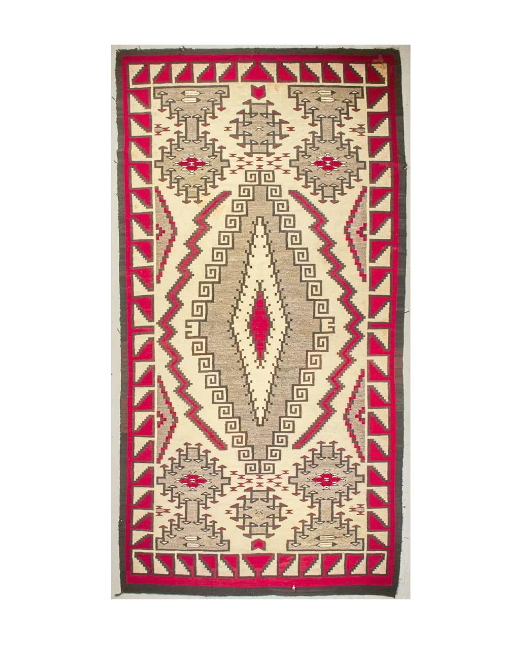 Angeboten wird ein seltener antiker Navajo-Teppich, ein wahrhaft prächtiges Textilstück aus den 1920er bis 1930er Jahren. Dieses Klagetoh-Gewebe zeichnet sich durch seine enorme Größe (68 x 131 Zoll), seine komplizierten Muster und seine