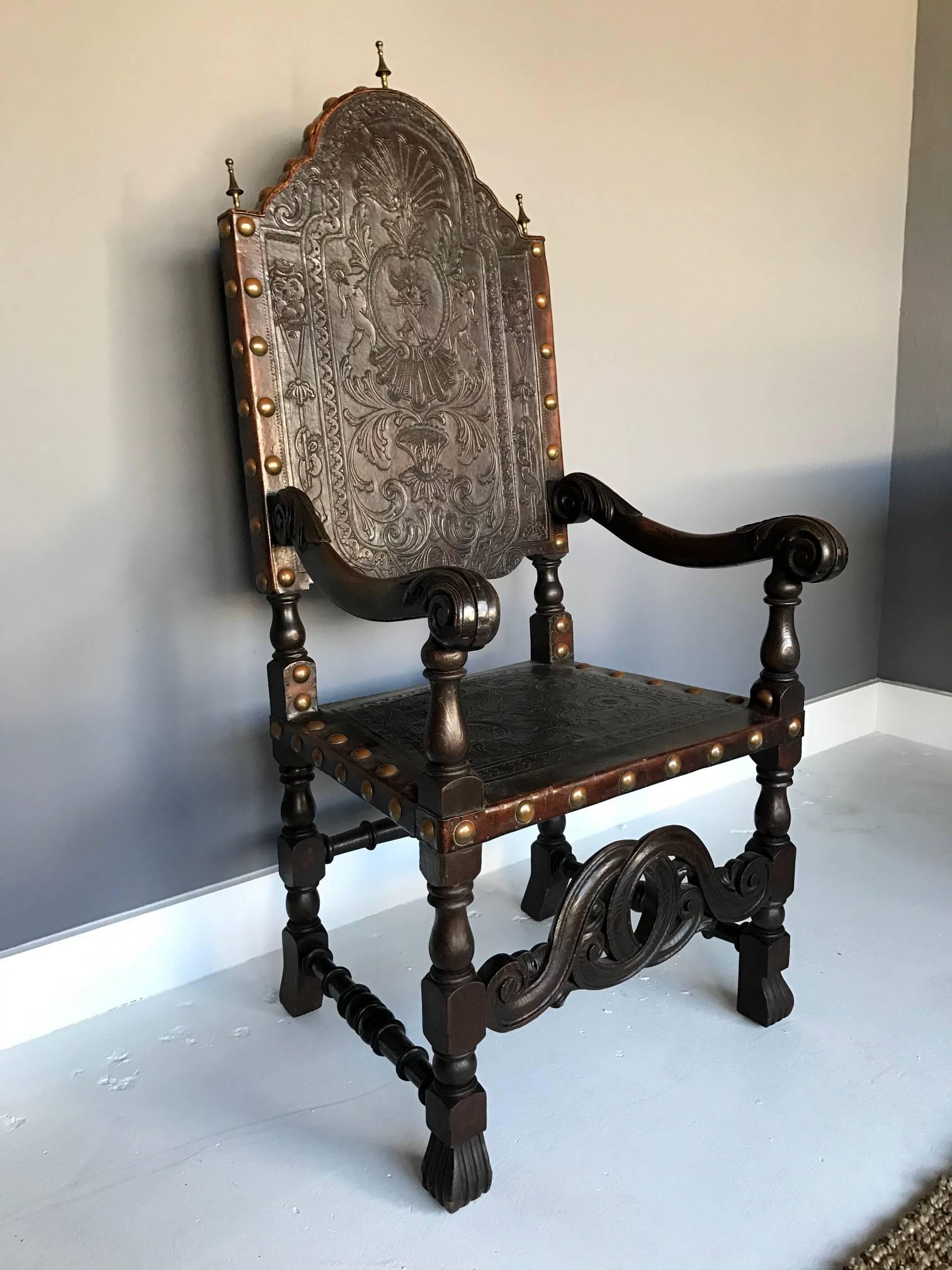A beautiful Portuguese embossed leather armchair circa early 19th century. It features a shaped scalloped crest, scrolling acanthine arms, embossed leather back and seat with foliate, shell-form and figurative designs, bronze finials and large tacks.