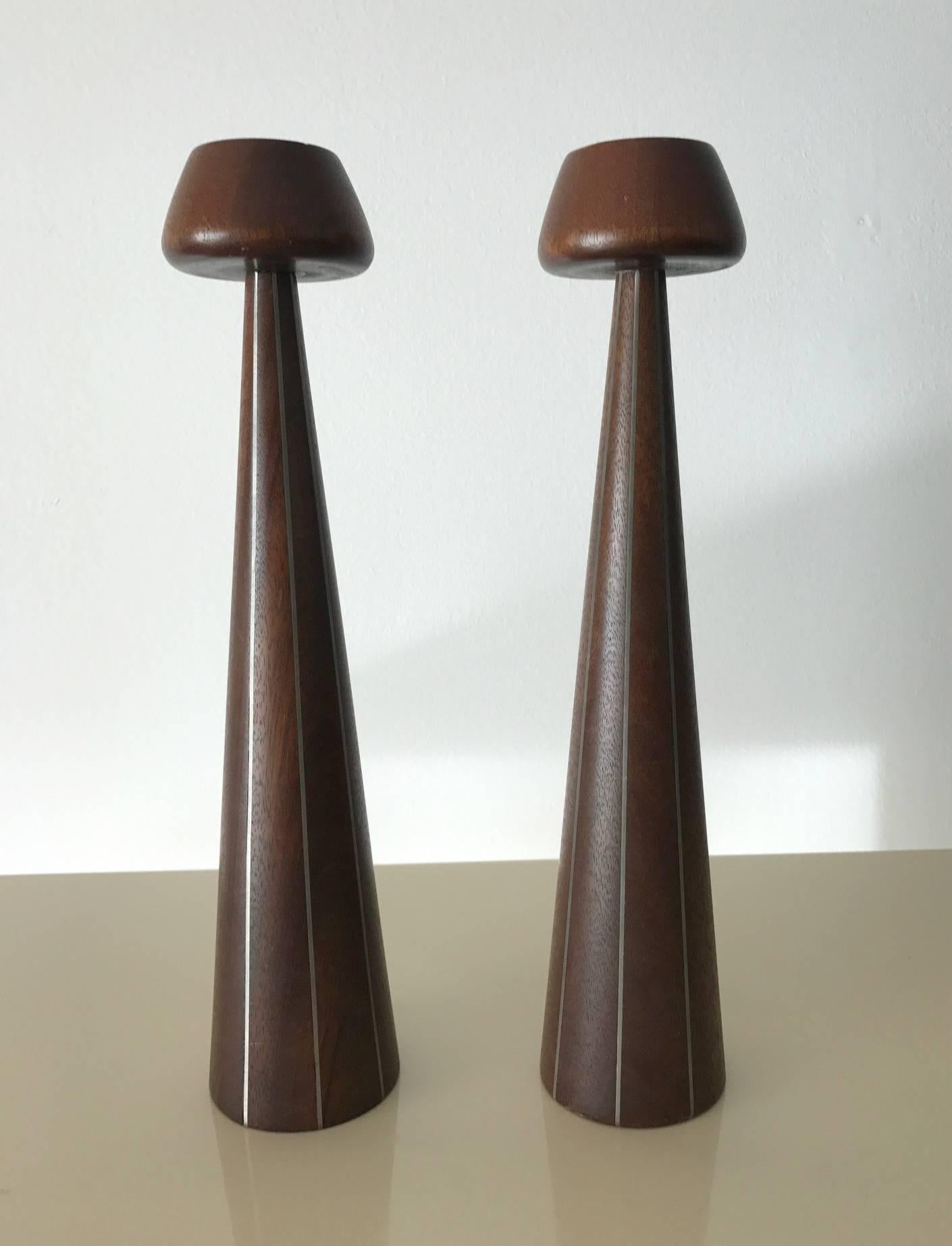 A design from Designers Inc, an early collaboration between Paul Evans and Phillip Lloyd Powell in the 1950s where they had their studios and joined showroom in New Hope, PA. The pair of candlesticks featured turned walnut with pewter inlays. As