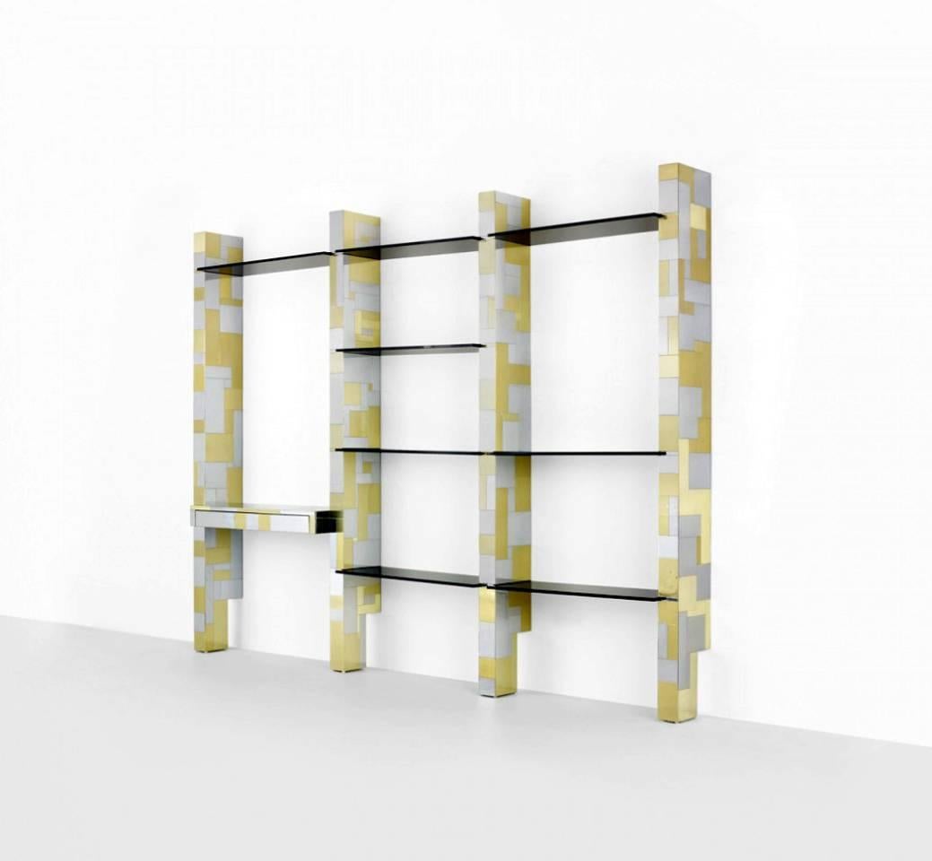 A custom made large wall unit by Paul Evans Studio for Directional. It consists of four portals with cityscape brass and chrome patchwork that support eight smoke glass shelves and a console desk befit with a single drawer. Visually stunning at its
