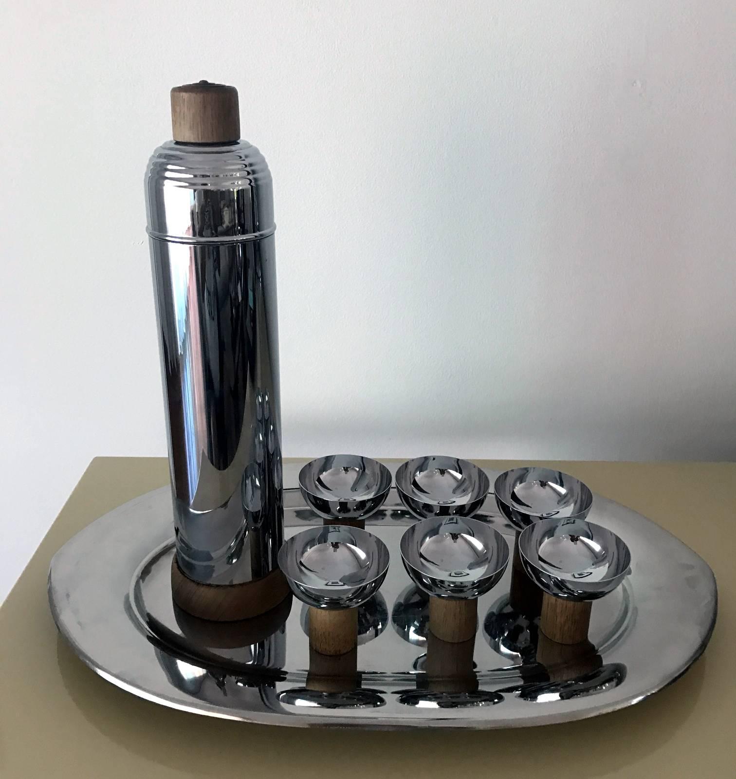 A very cool set of Art Deco style service set from machine age of Japan circa postwar1950s. The chrome set is consist of a carafe with lid, a large tray and six cups with wood accents. The geometrical design is simple and elegant. It has a versatile