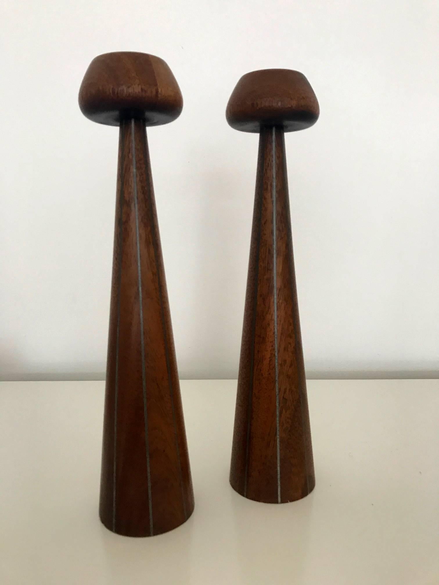 A design from Designers Inc, an early collaboration between Paul Evans and Phillip Lloyd Powell in the 1950s where they had their studios and joined showroom in New Hope, PA. The pair of candlesticks featured turned walnut with pewter inlays. As