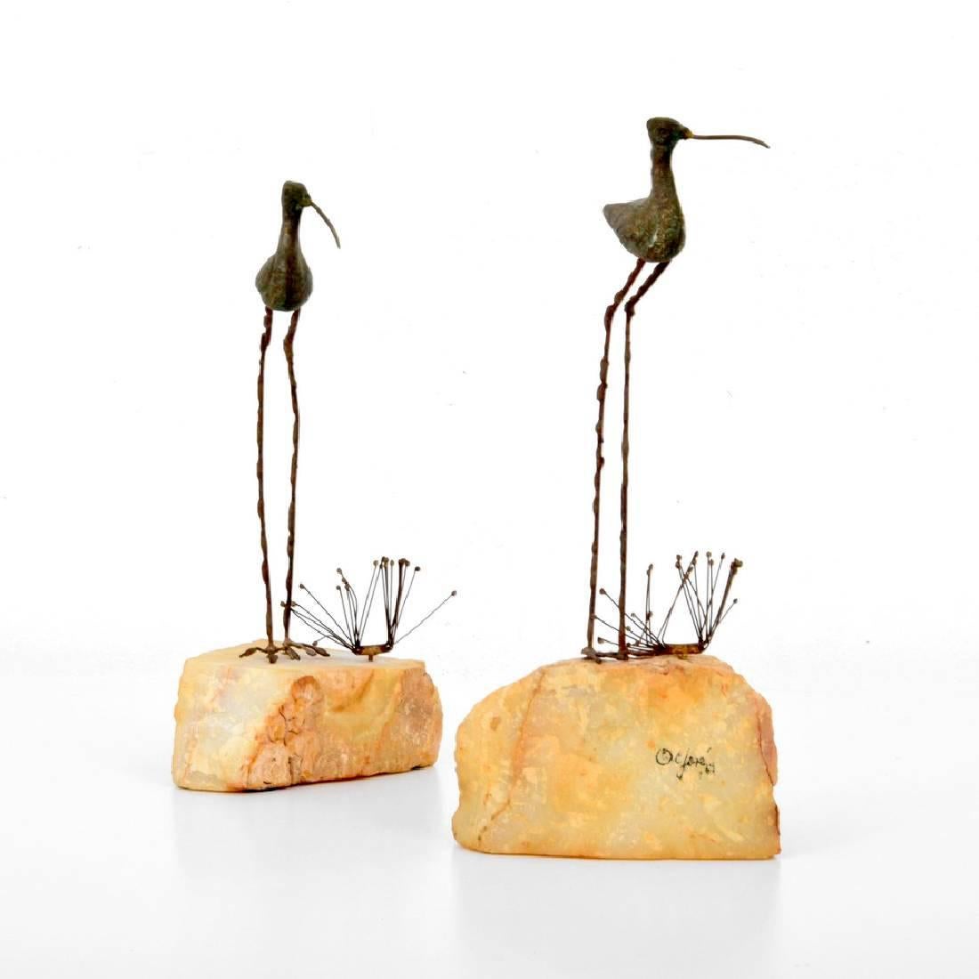 A pair of bronze sculpture on rocks by Curtis Jere for Artisan House dated 1969. Patinated bronze depicts egrets and grasses perched on natural rocks, in a very poetic Zen style. The tall one is 13.75 inch H by 5.25 W by 4 D; the short one is 12.25