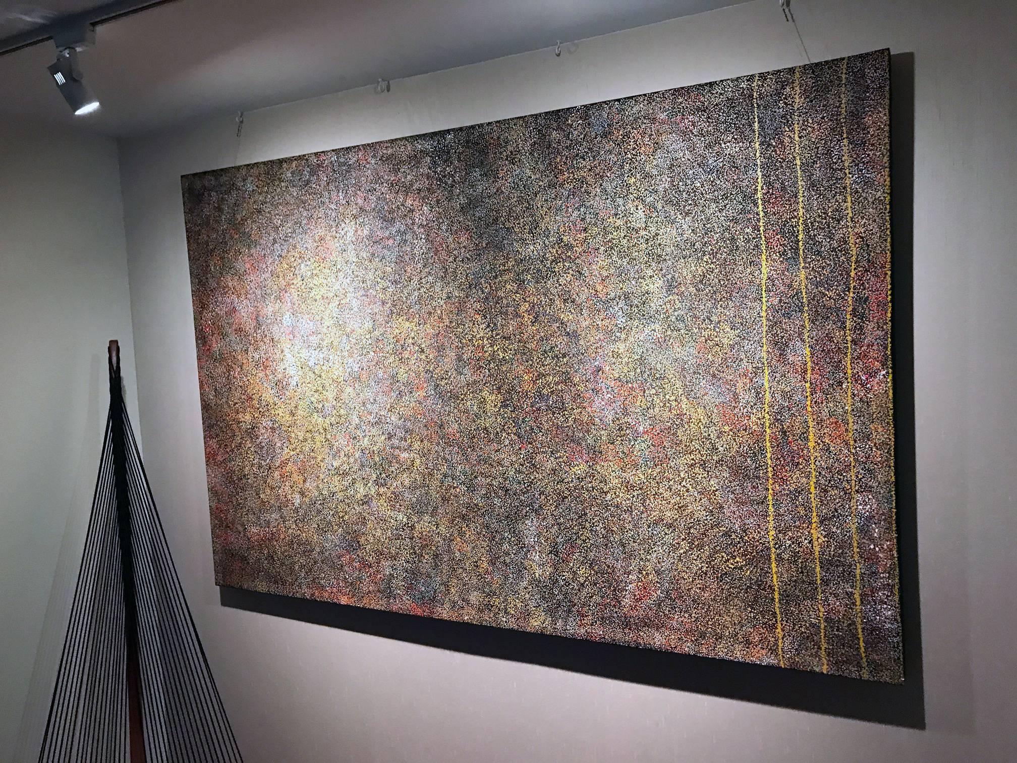 This large painting is one of the two frequent designs by the famed aboriginal artist Kathleen Petyarre which depicts the artists' home country. By using minutia of dots in different hues, the artist created an impression of aerial view of her home