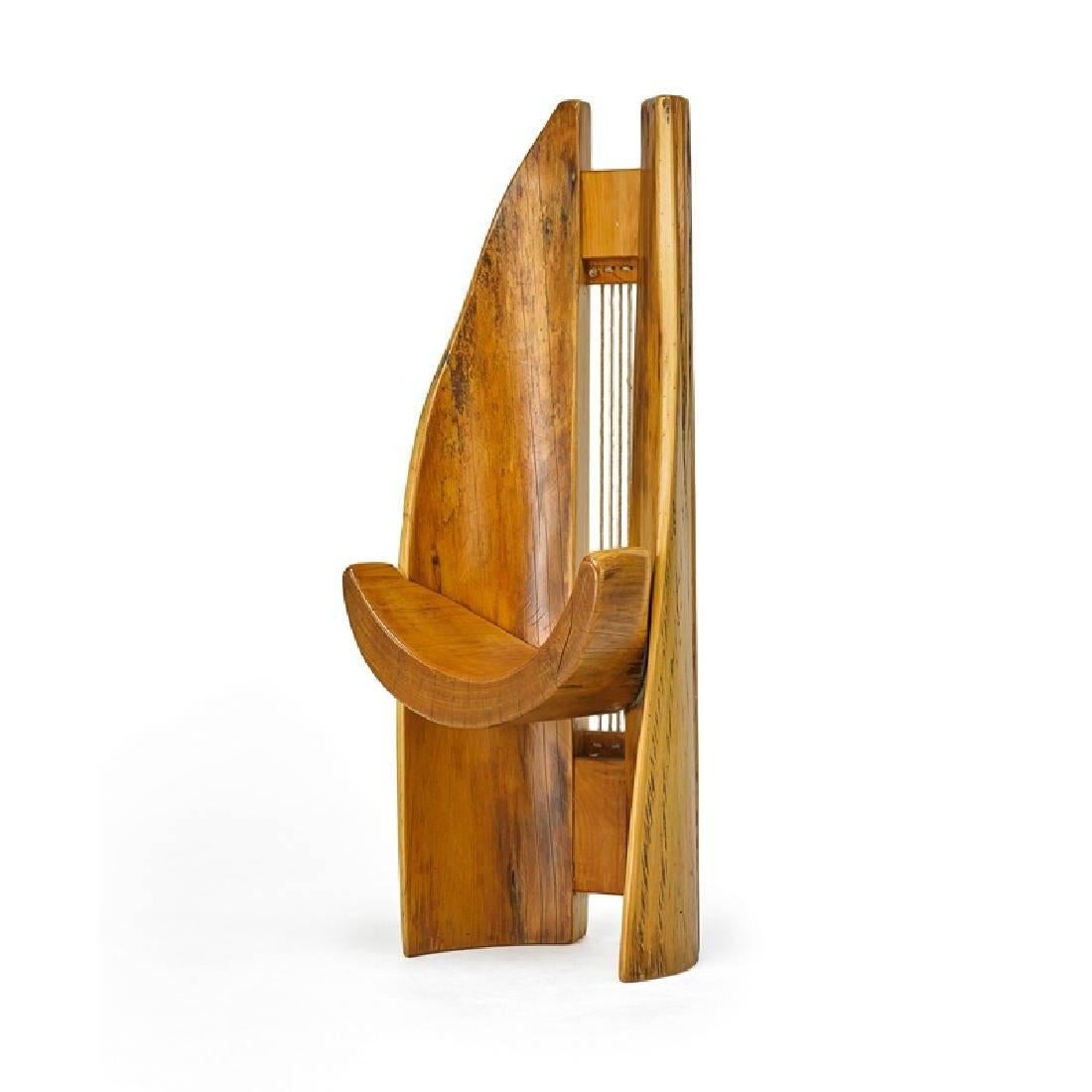 A tall sculptural chair designed and made by Hugo Franca (b. 1954), a Brazilian furniture artist known for his use of reclaimed wood from his native country and an organic approach to his design that highlight the intrinsic beauty of the wood, the
