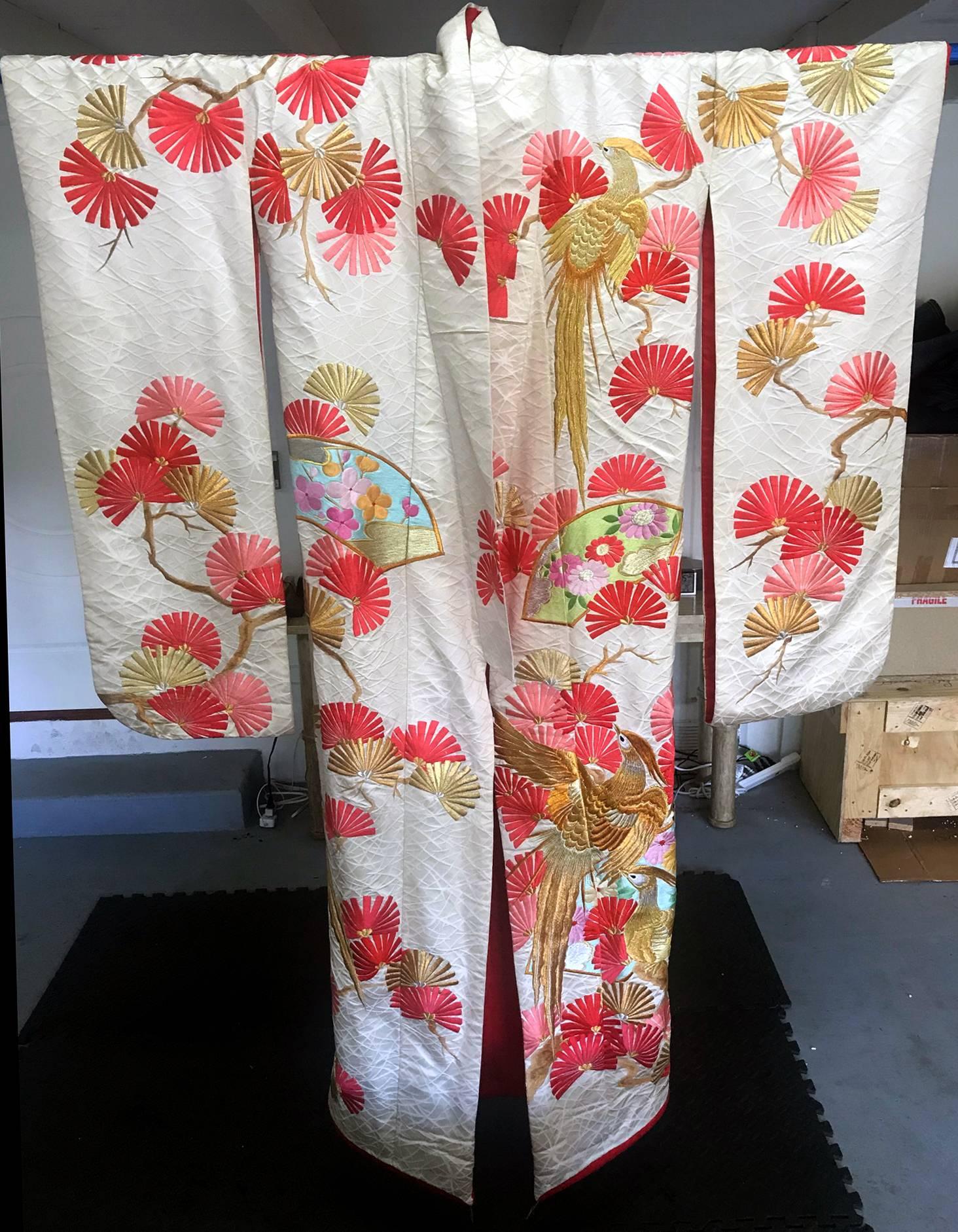 Un très beau kimono de cérémonie japonais, circa 1930-60s dans un style Art Déco oriental. Fond texturé en soie blanche avec une broderie élaborée et complexe en couleurs, fils d'argent et d'or. Le devant et le dos du kimono représentent des
