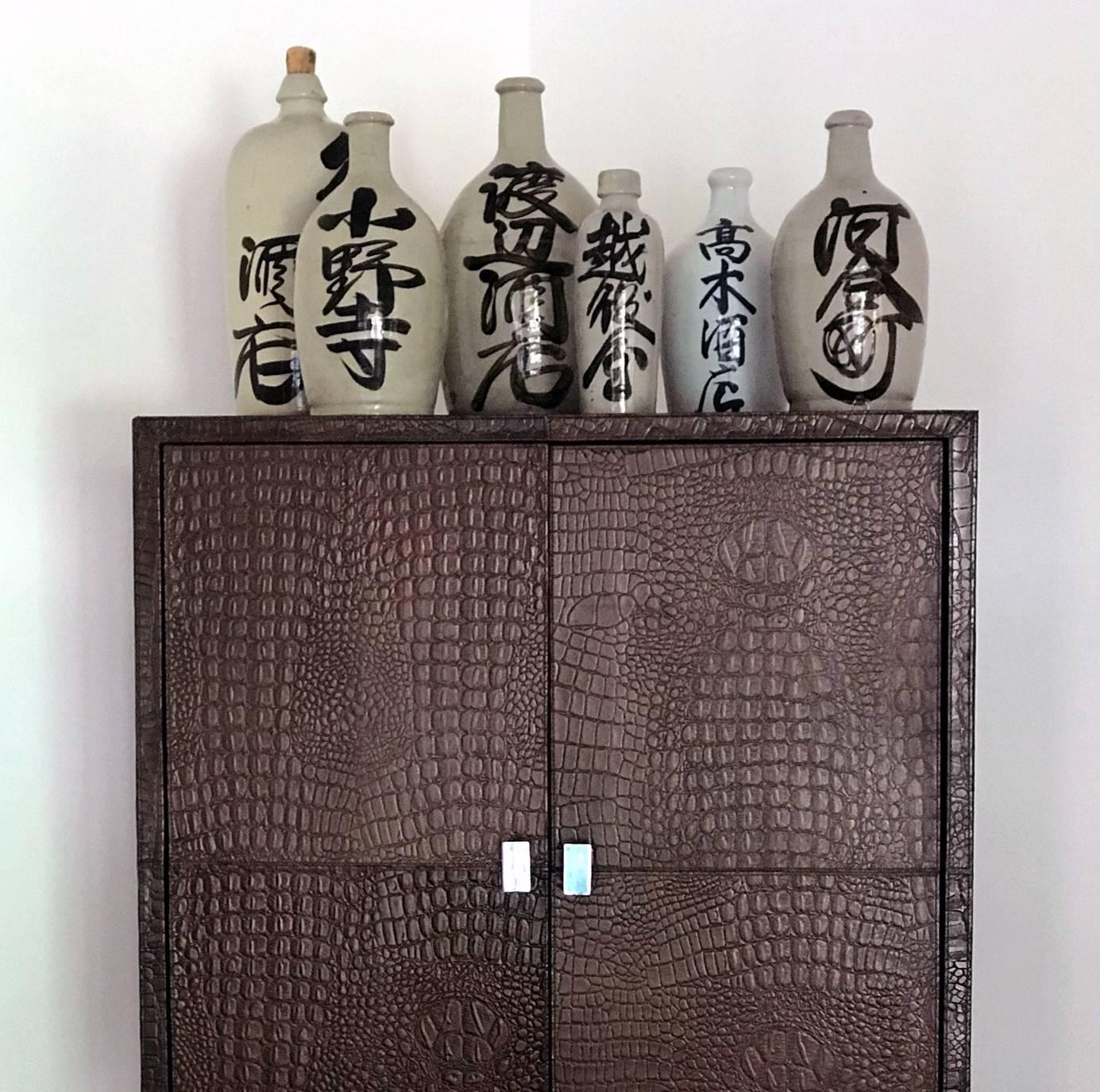 A very cool collection of seven antique Japanese Sake bottle made of ceramic stoneware from Meiji Period, circa 1890s. Of various sizes with the largest one are 17 inches in height and 8 inches in diameter, and the smallest being about 10 inches