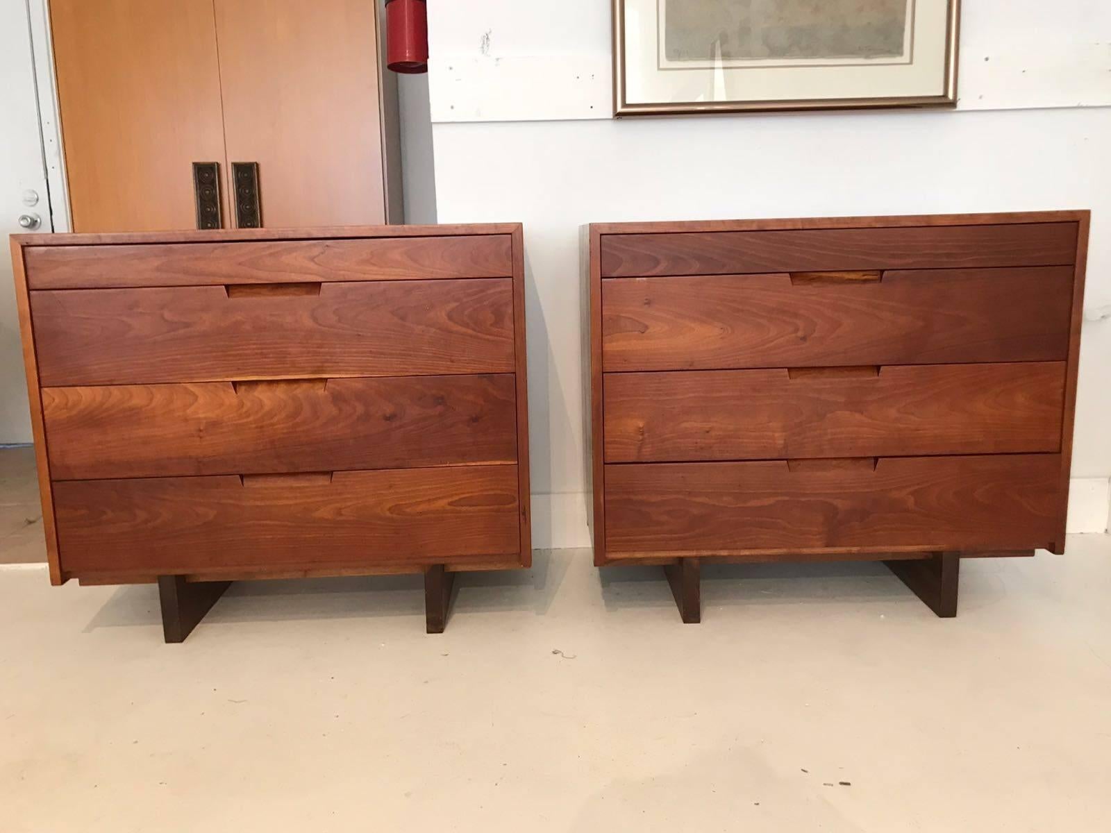 An excellent pair of four-drawer dressers custom-made by George Nakashima in his New Hope Studio in 1970. Constructed in highly figured cherry in a Minimalist rectangular forms with exposed dovetail joints on sap block base, these pieces exemplify