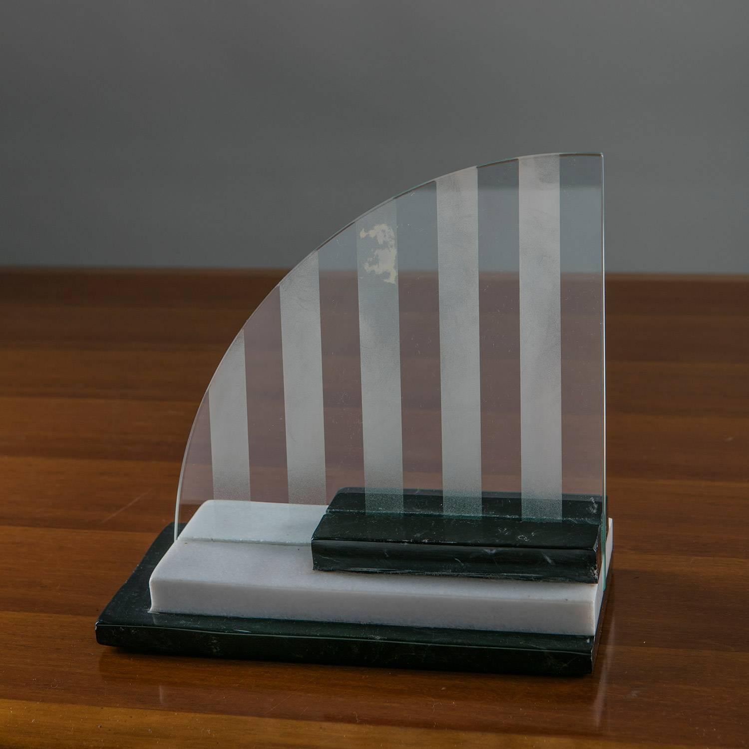 Italian marble picture frame / centerpiece manufactured by Skipper.
Three marble slabs host the curved shape glass with sandblasted and transparent stripes.