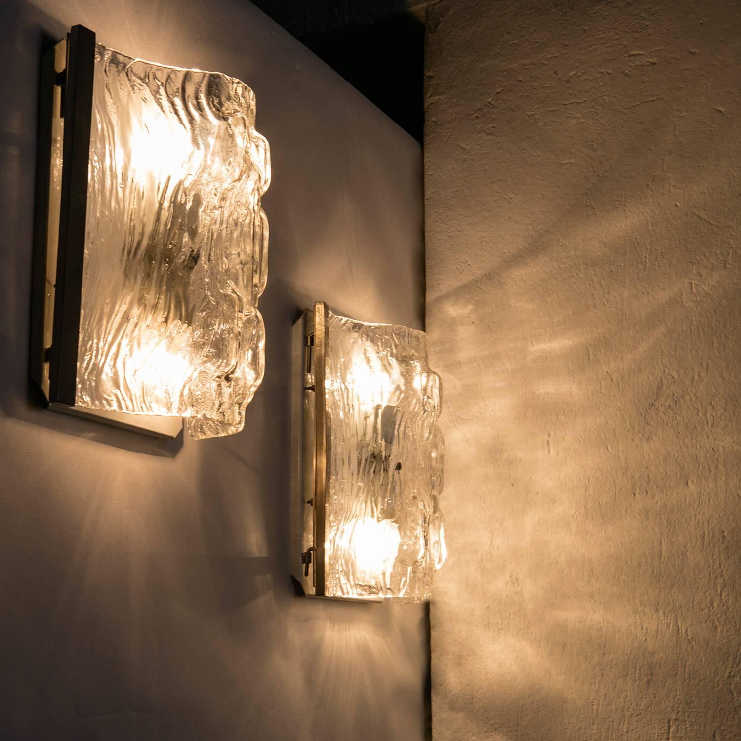 Rare pair of Murano glass wall lamps by Toni Zuccheri for Venini.
Thick molded crystal shaded are hinged to the wall plate.