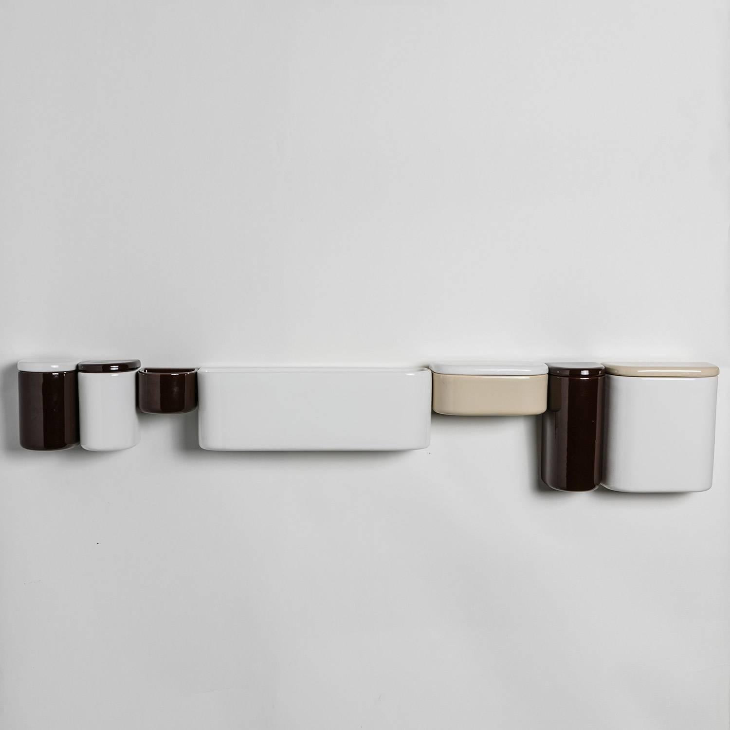 Adjustable ceramic wall units by Sicart, Italy.
Enameled ceramic boxes freely positioned along the metal bar on the wall.
Three different heights and widths, white, black, red and brown colors
available.