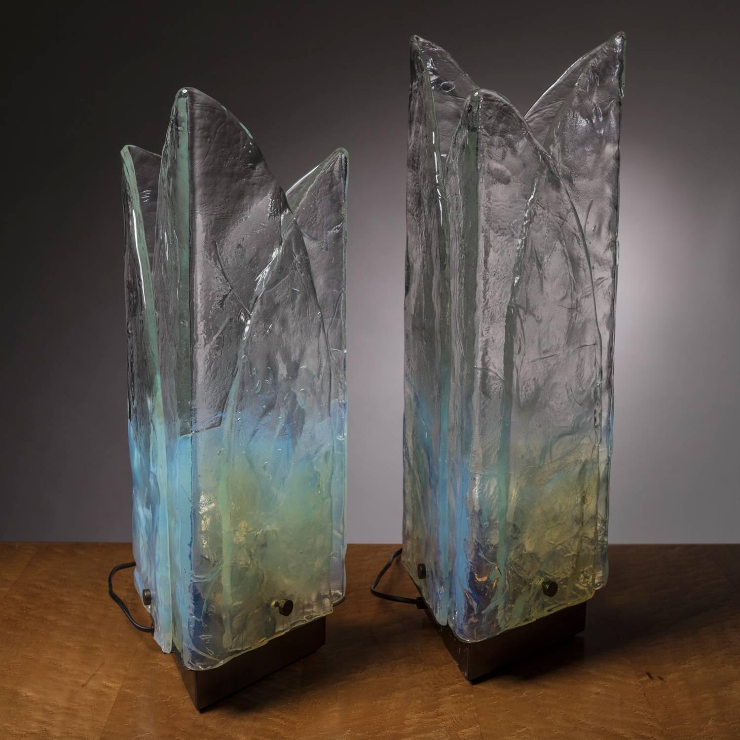 Stunning pair of Mazzega table lamps.
Each lamp is composed by three folded thick Murano glass leaves, fastened together with brass screws to the base.